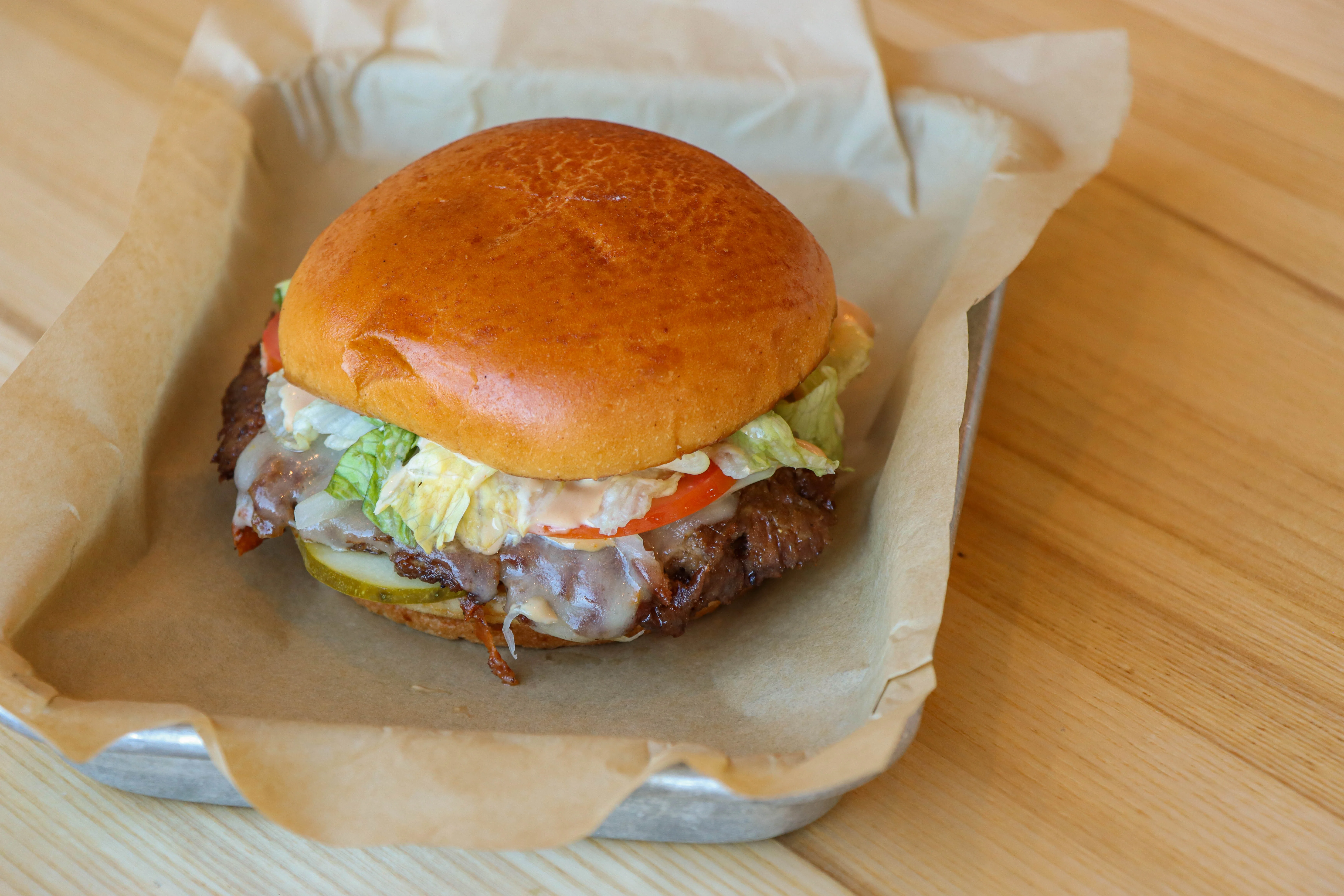 A smash burger with lettuce, tomato, and cheese