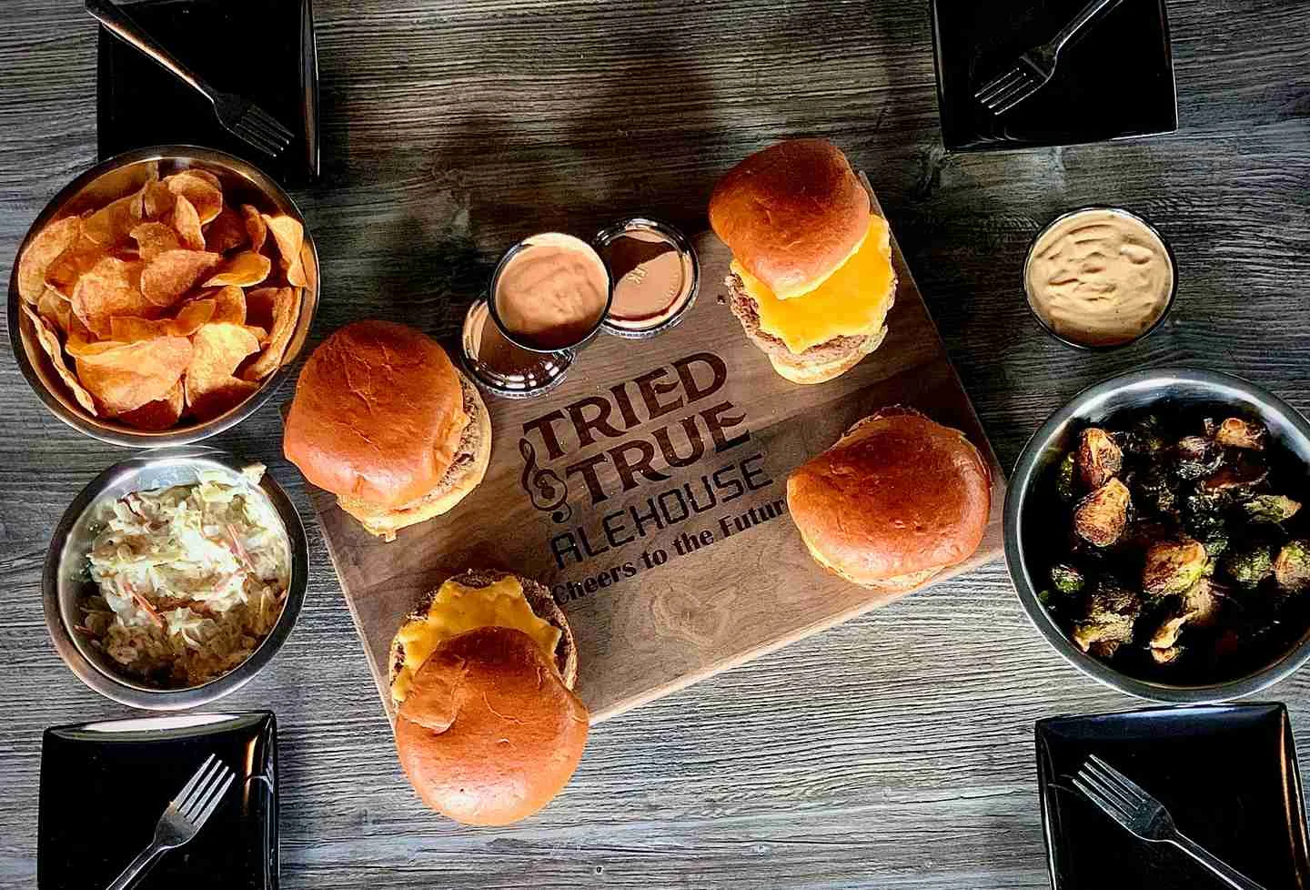 Gourmet cheeseburgers with sides at a casual alehouse