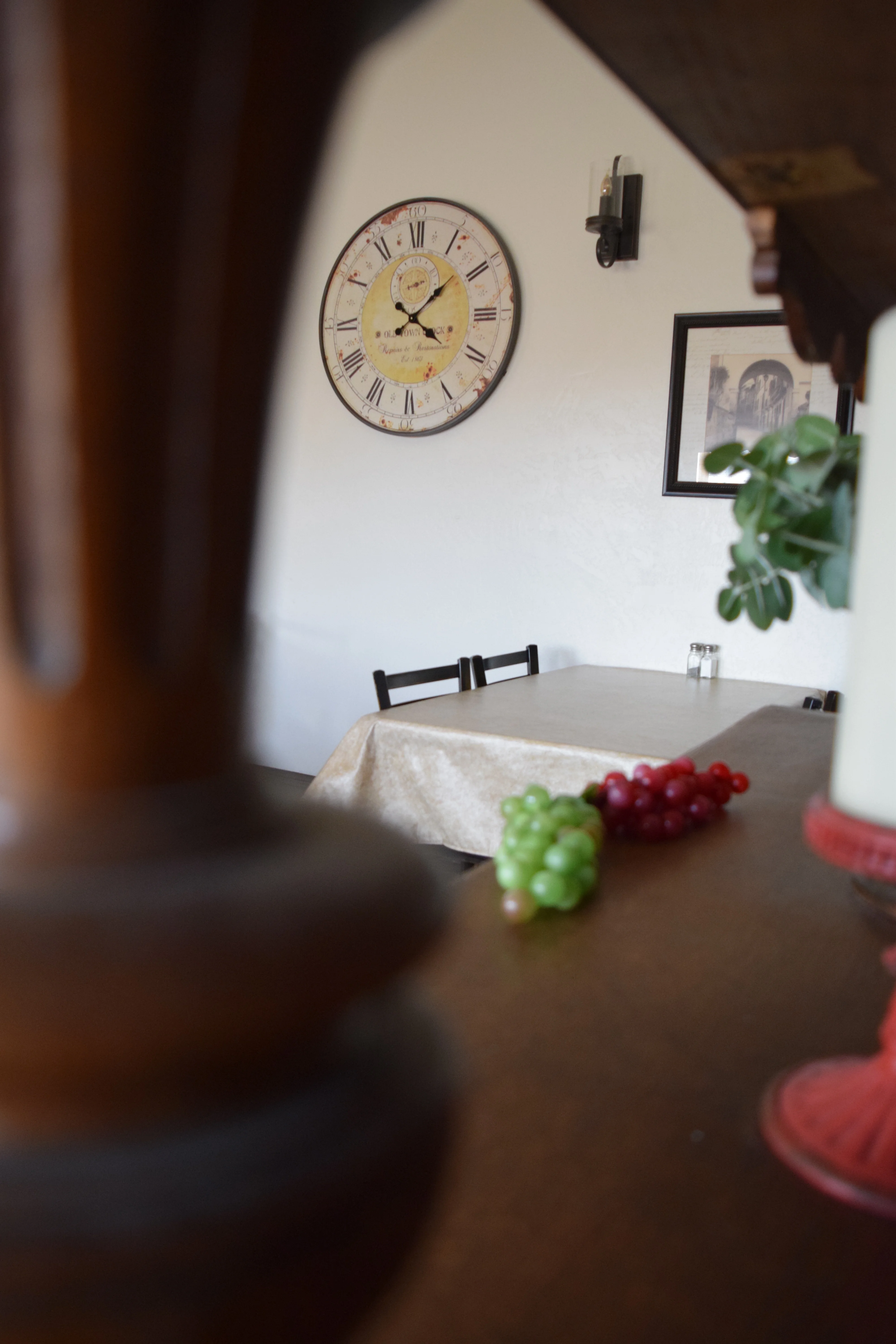 Cozy restaurant interior with a vintage clock and grapes on the table