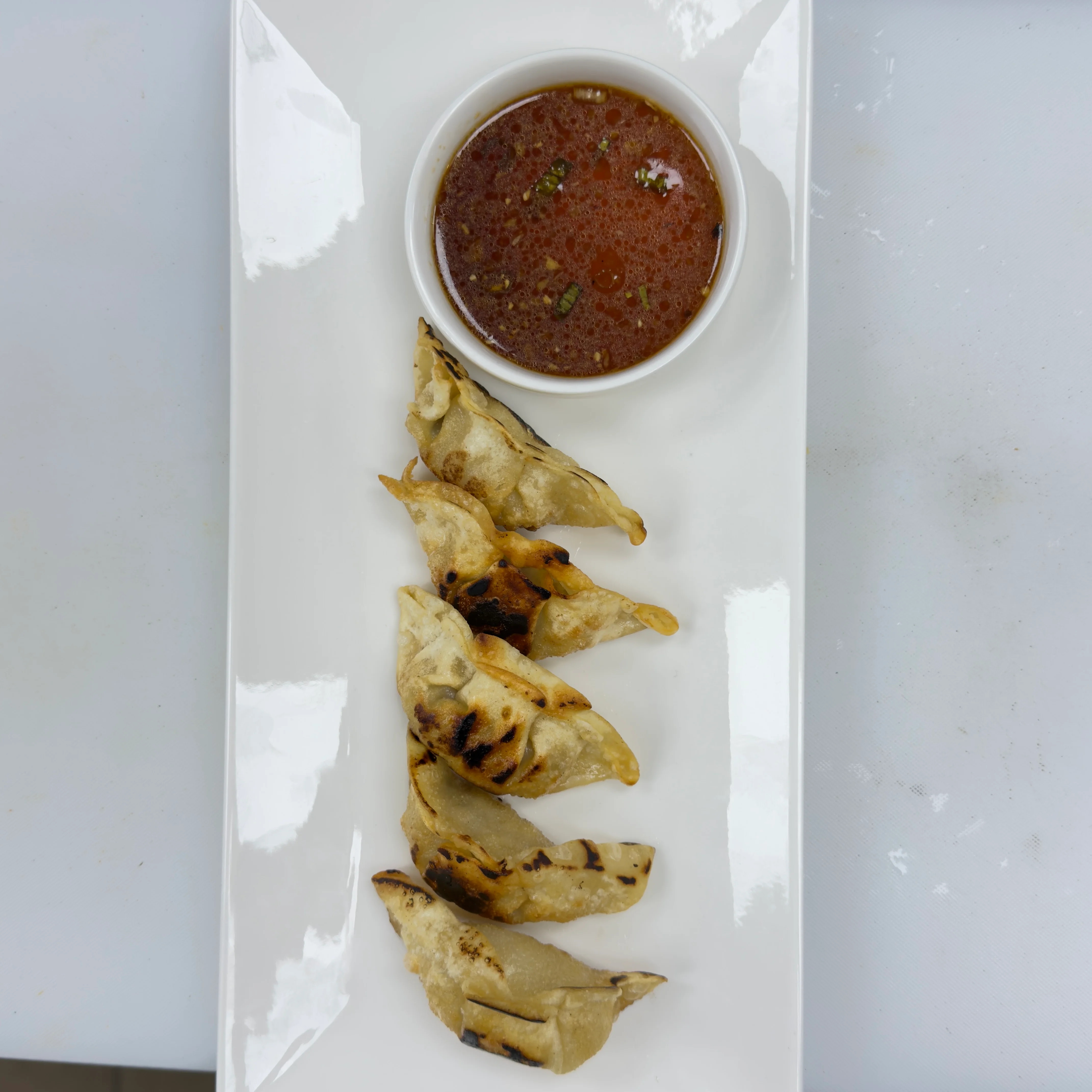 Grilled dumplings served with dipping sauce