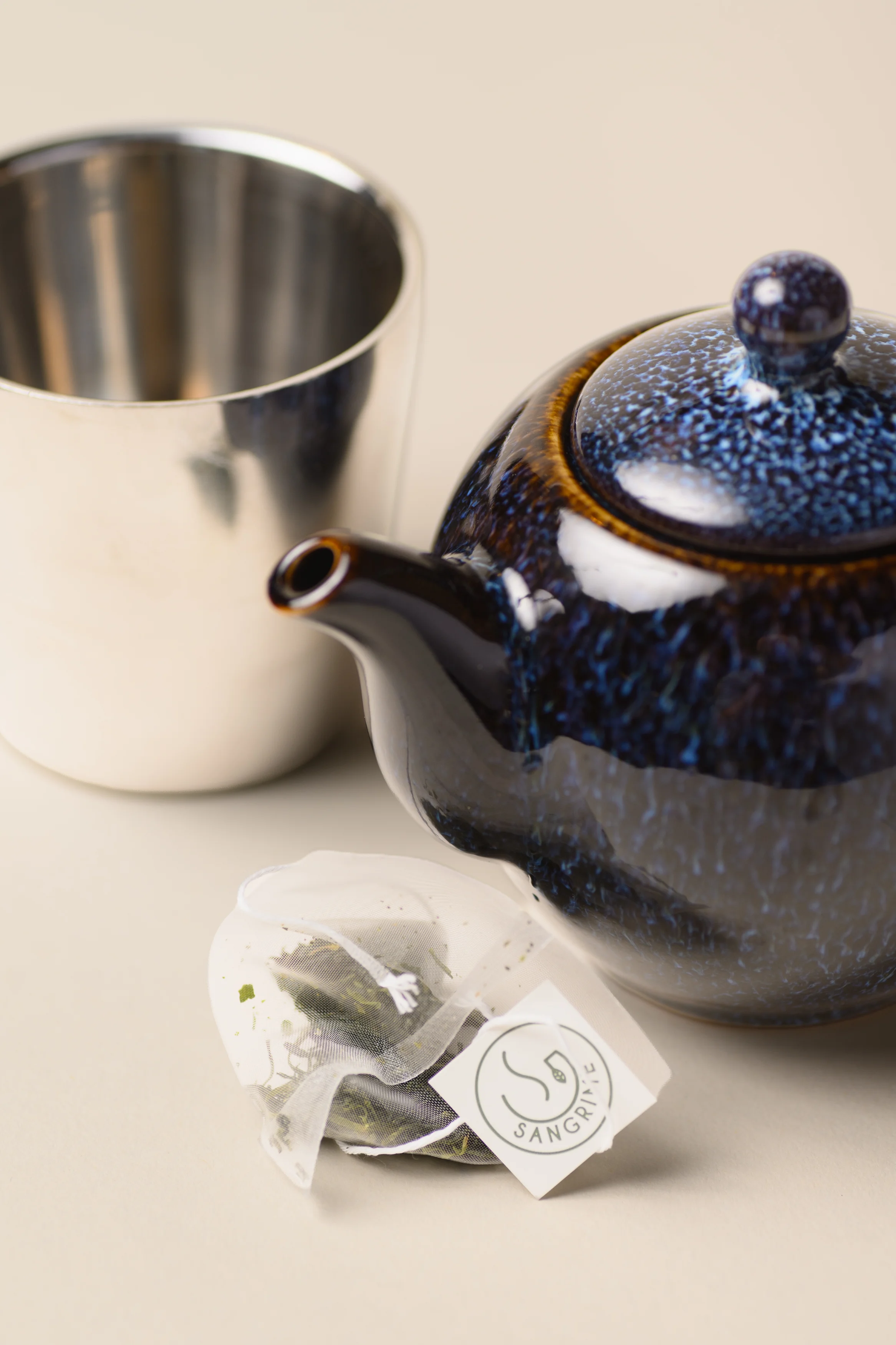 Elegant tea set with a blue teapot and herbal tea pouch