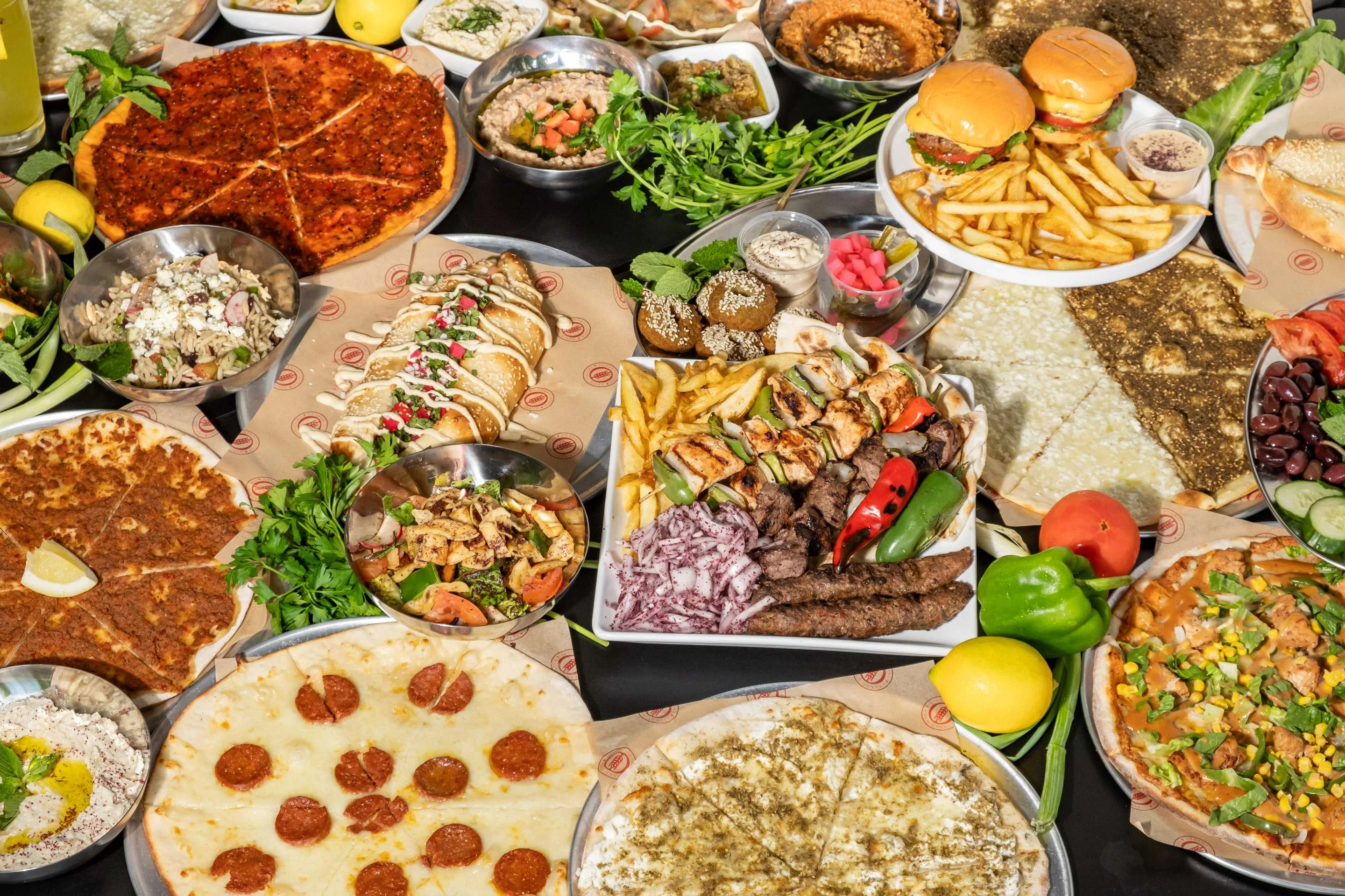 A variety of delicious dishes including pizza, kebabs, and salads.