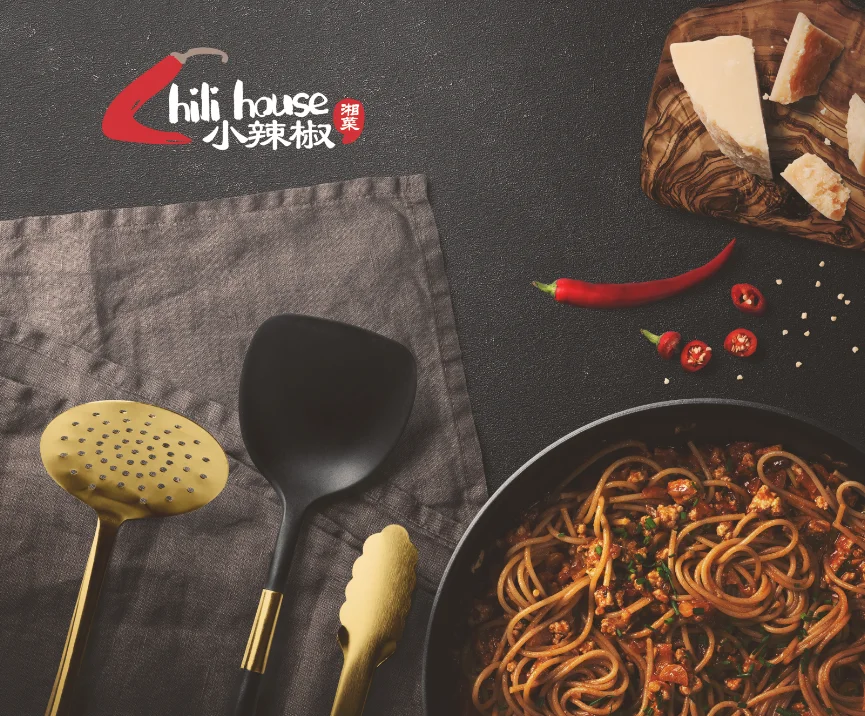 Spicy Sichuan noodles in a black bowl with fresh herbs