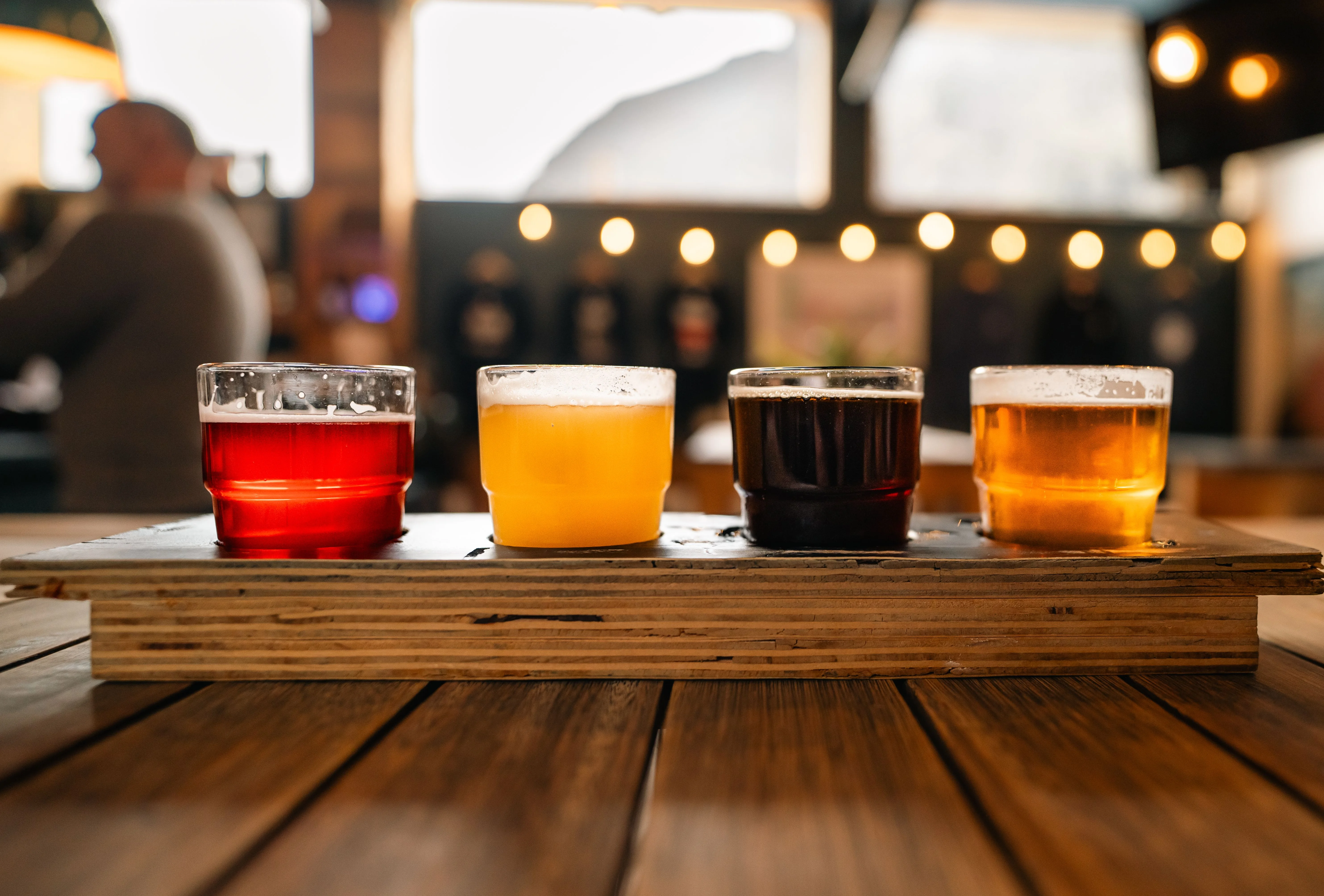 Craft beer flight with four colorful brews in a rustic bar setting