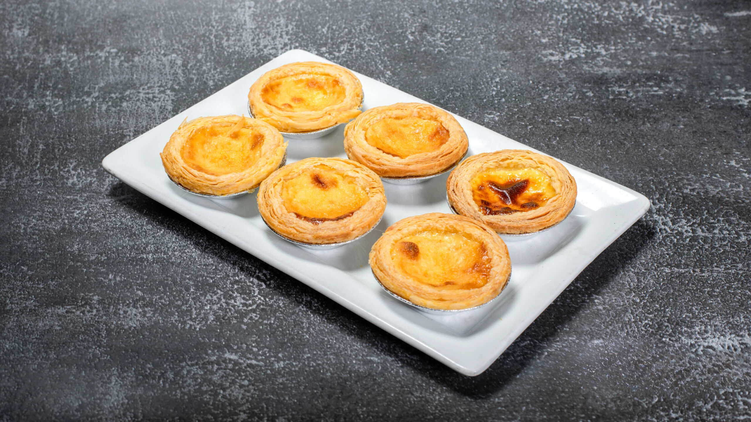 Image of our egg tarts. Available for delivery like our other items. We offer cake mini, cake rolls, boba tea, and coffee for carry out. Online orders through  DoorDash grub hub and Uber eats