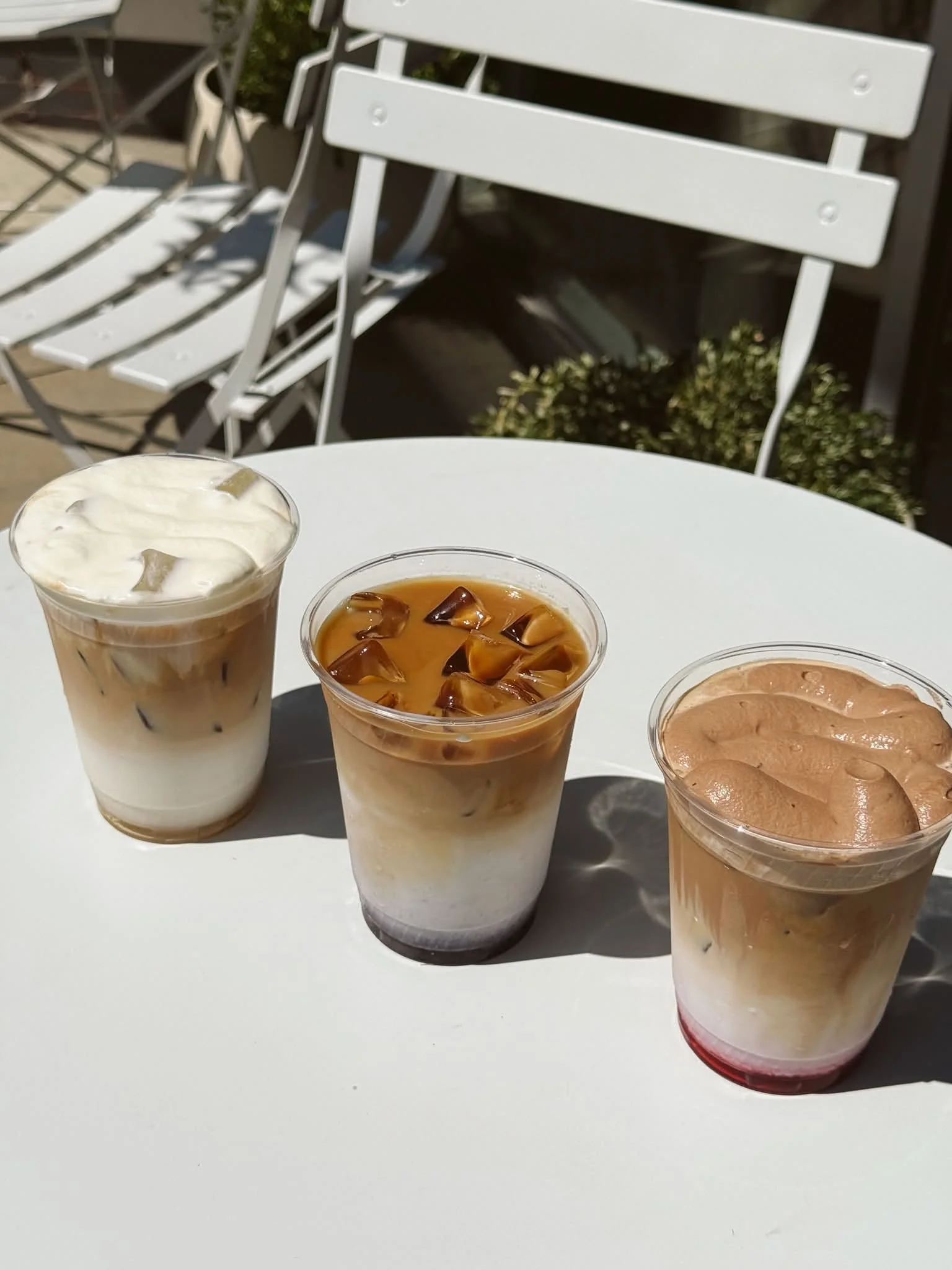 Iced coffee drinks with layered textures on a sunny table