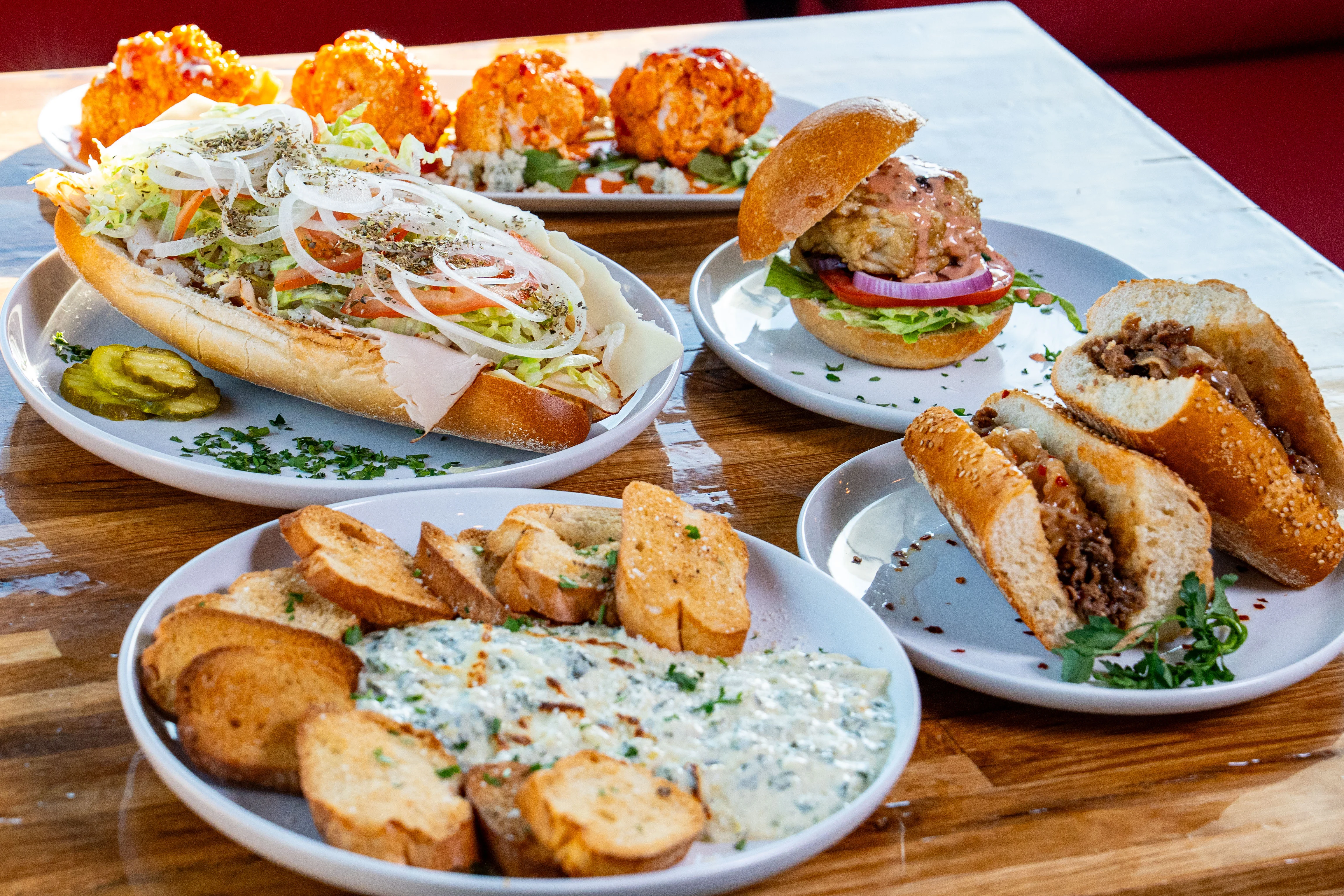 Delicious assortment of gourmet burgers and fries on a wooden table.