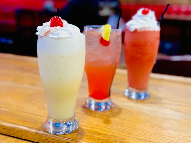 A variety of colorful drinks displayed on a table.
