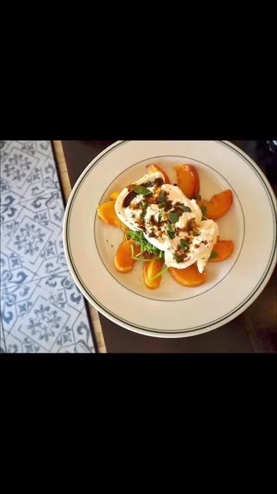 Burrata cheese with seasonal fruits and greens