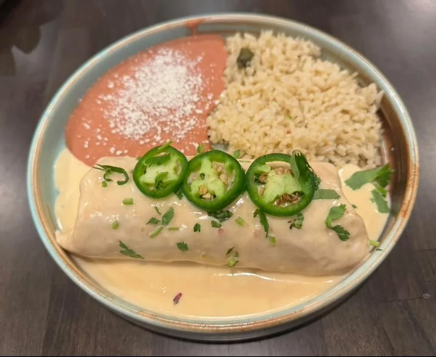 Creamy chicken enchiladas with rice and refried beans