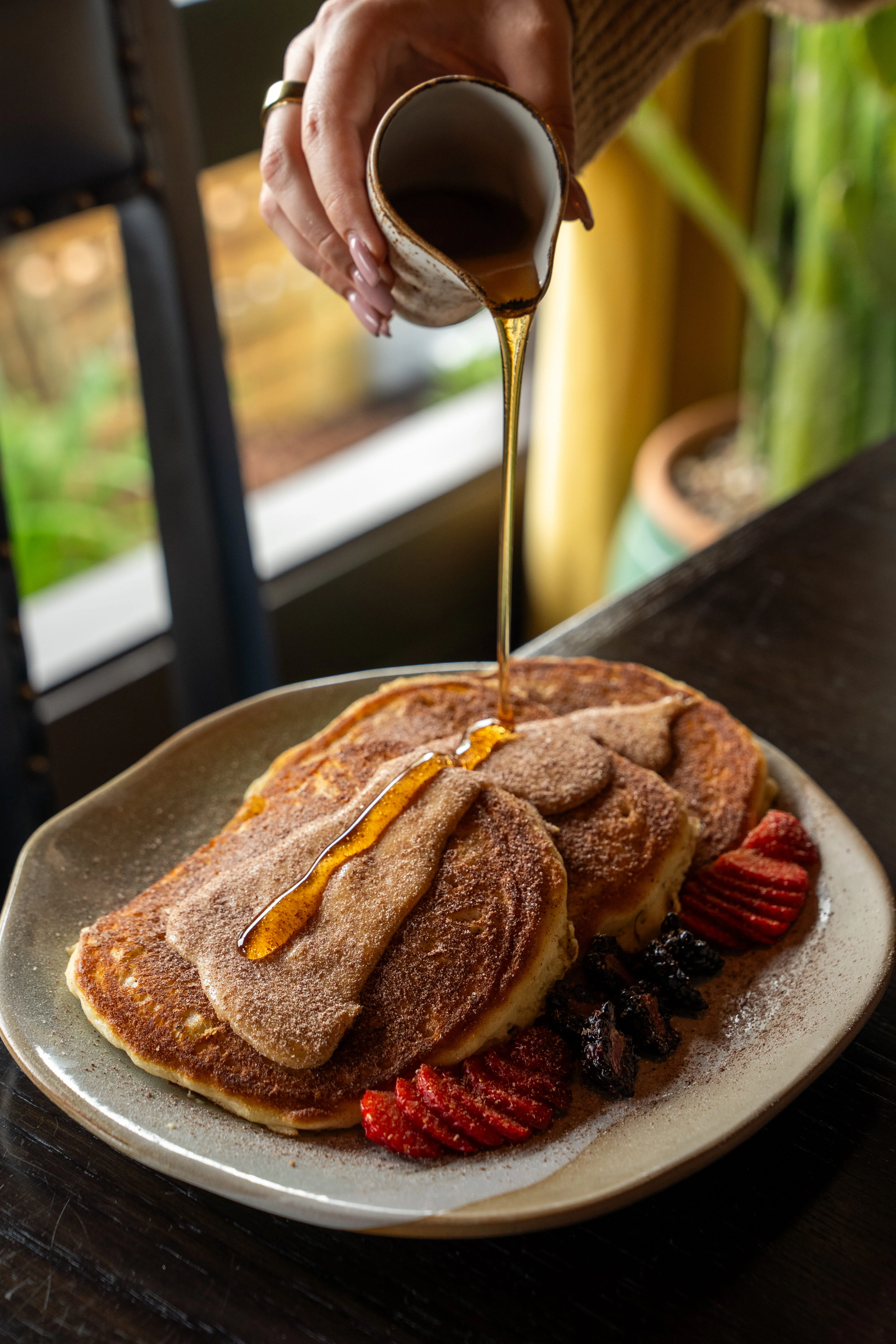 Fluffy pancakes drizzled with syrup and fresh berries