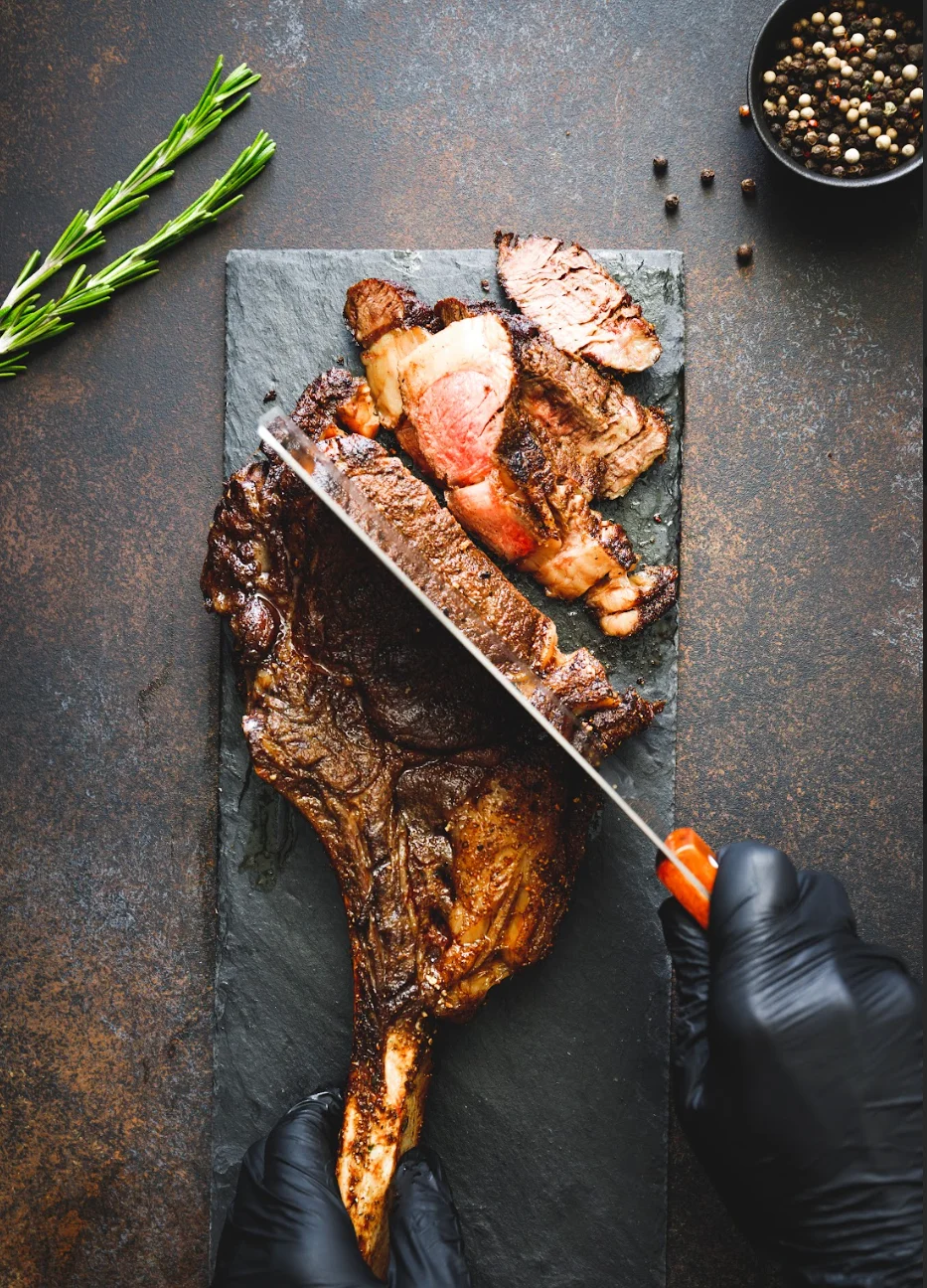 Sliced tomahawk steak on a slate board