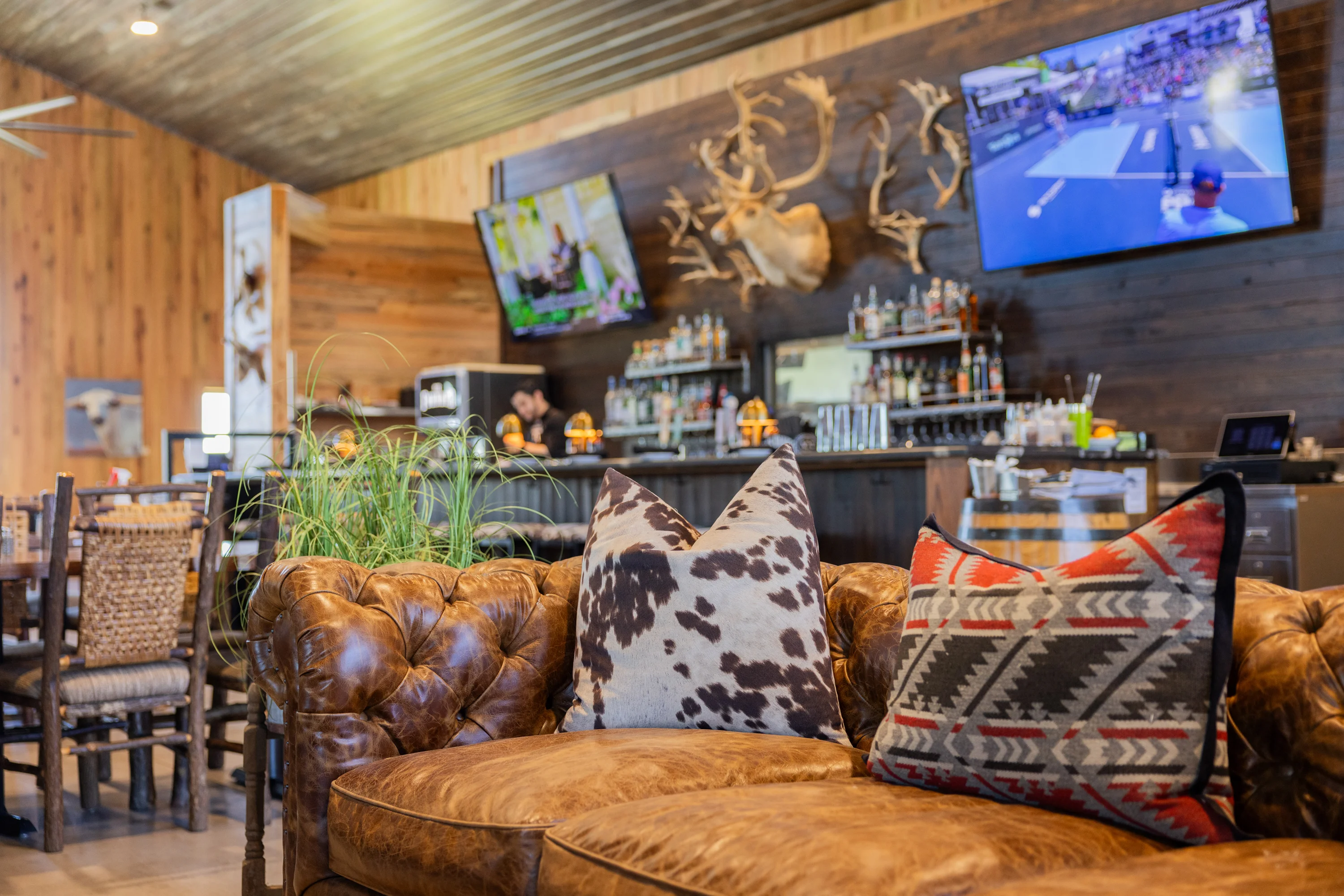 Cozy restaurant interior with leather seating and a bar area.