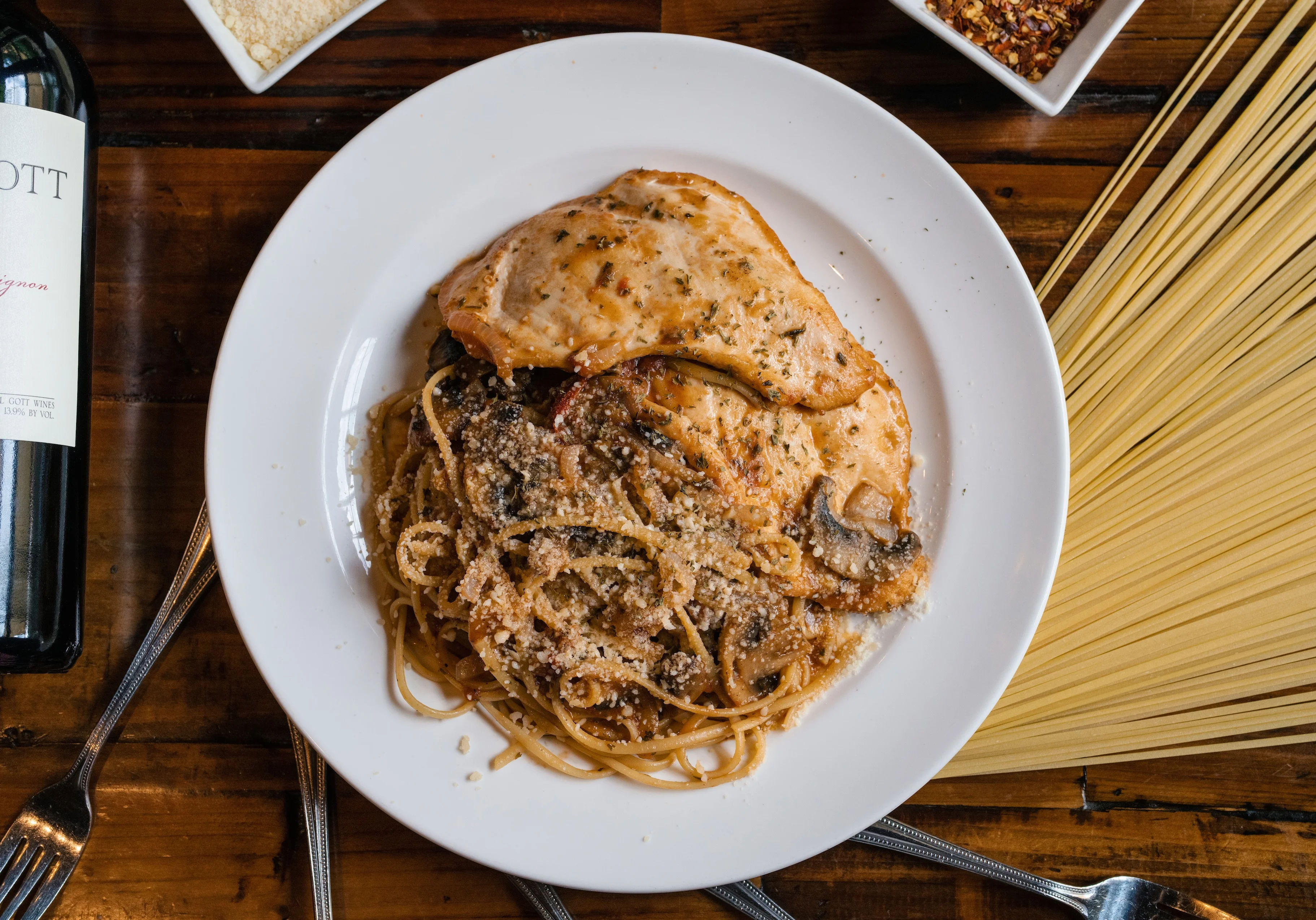 Italian chicken piccata with spaghetti and red wine