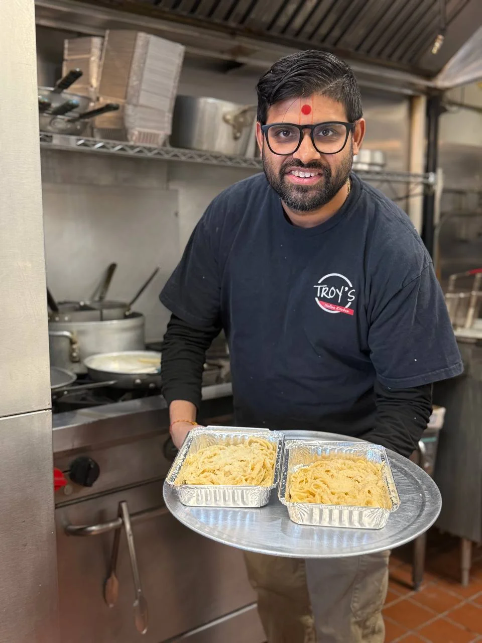 The owner of Troy's carrying two trays of food