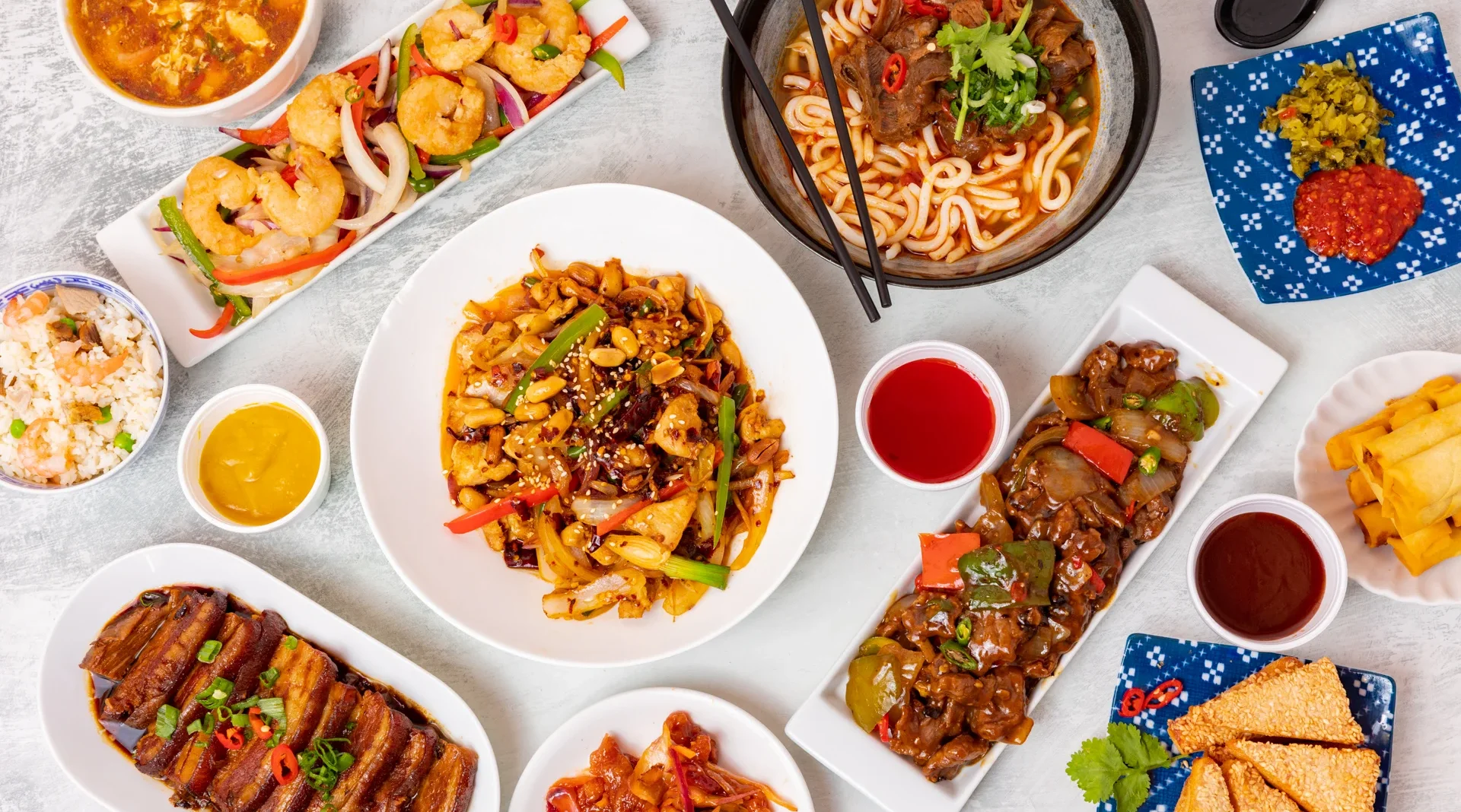 Assorted Chinese dishes including stir-fried noodles and shrimp with vegetables