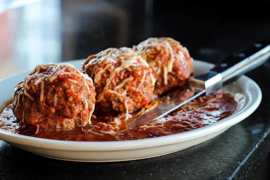 Italian meatballs in marinara sauce topped with cheese
