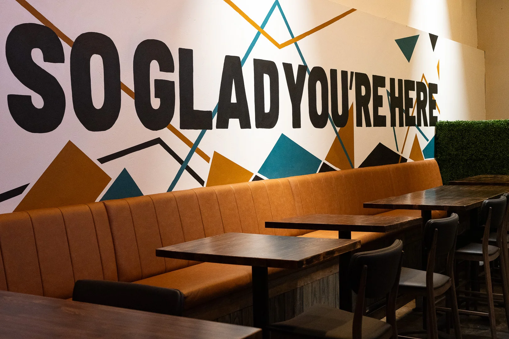 Cozy restaurant interior with welcoming mural and leather seating