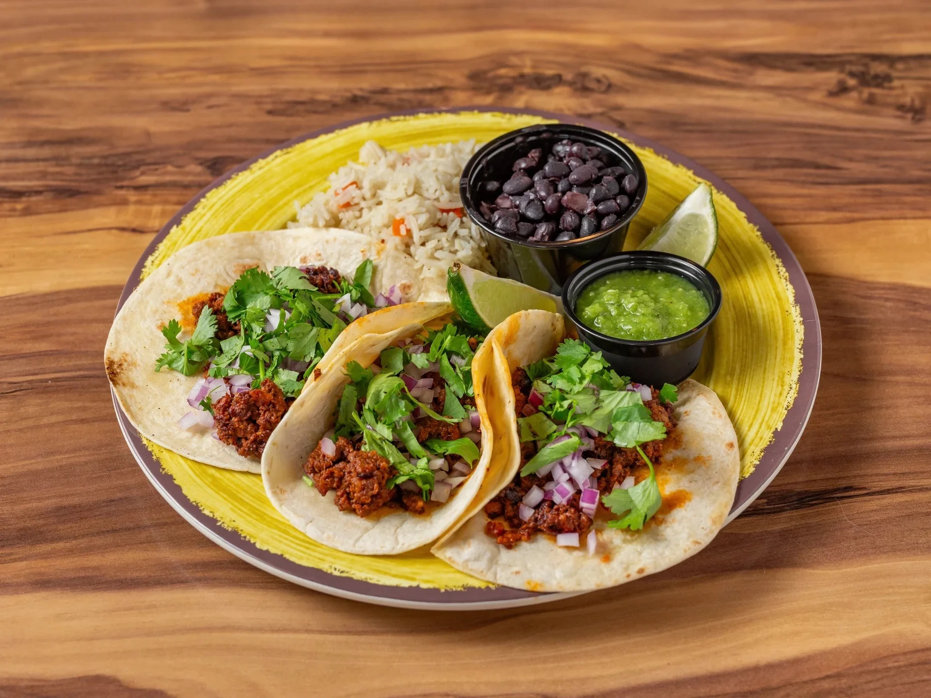 Authentic Mexican street tacos served with rice and black beans
