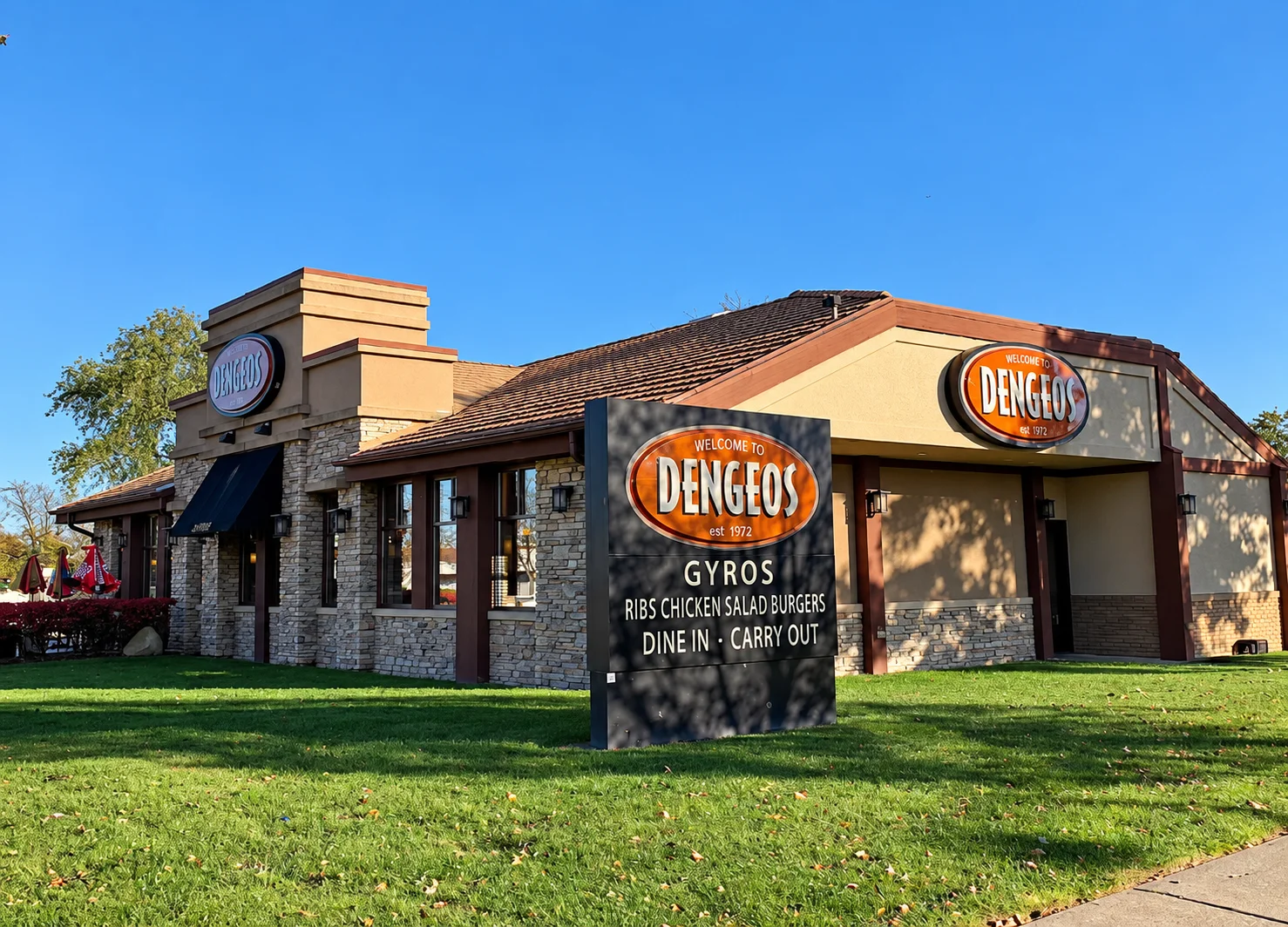 Exterior of a Greek restaurant with gyro, ribs, chicken, and salad signage