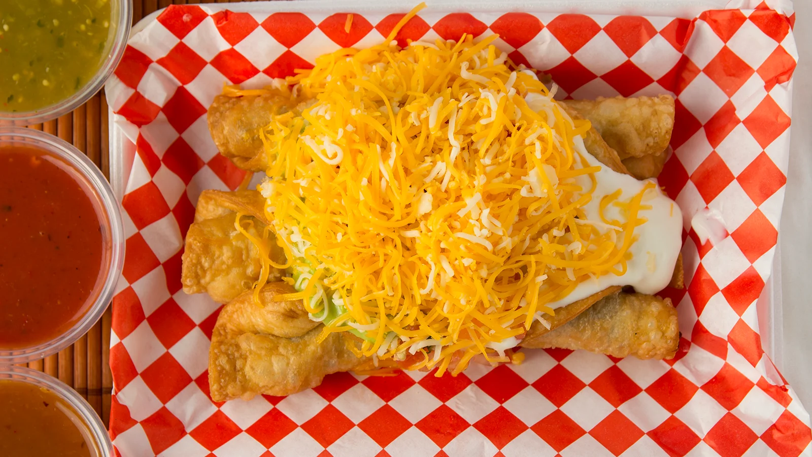 Crispy Mexican flautas topped with cheese and sour cream