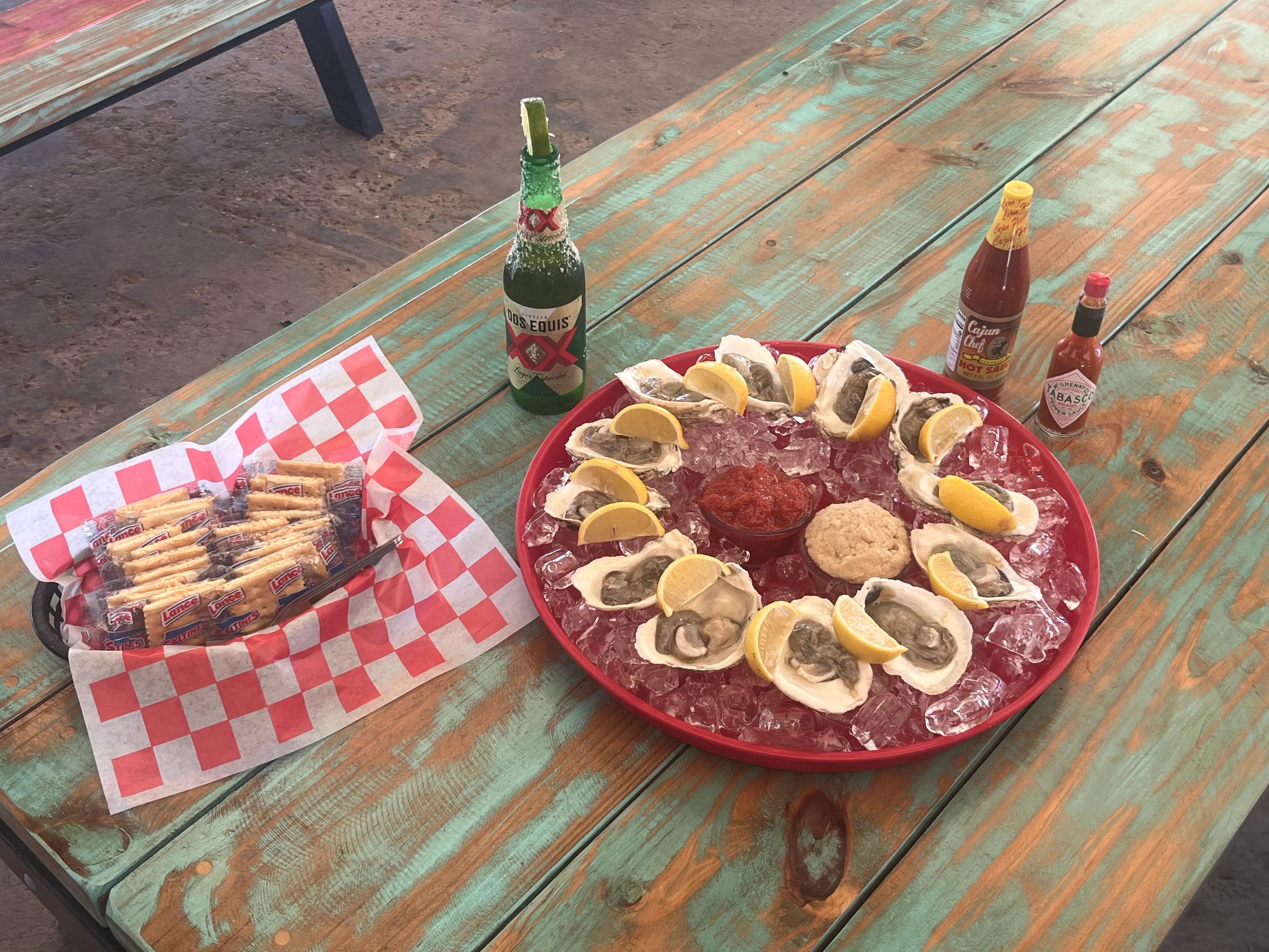 Fresh oysters on ice with lemon and hot sauce, served with snacks and beer