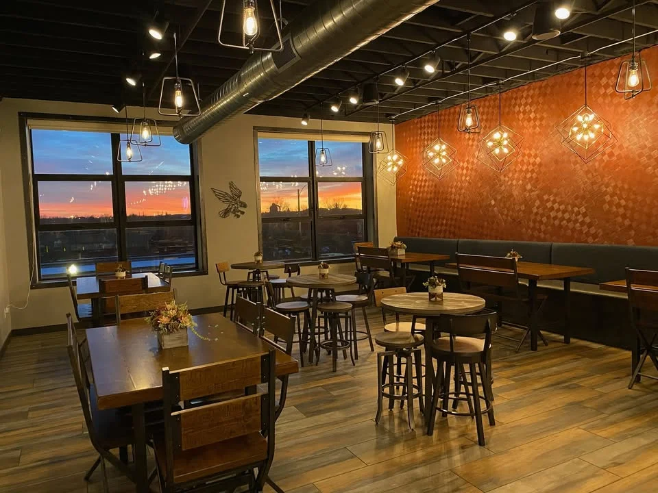 Cozy restaurant interior with warm lighting and sunset view