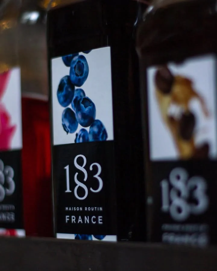 Bottles of 1883 Maison Routin syrups featuring blueberries
