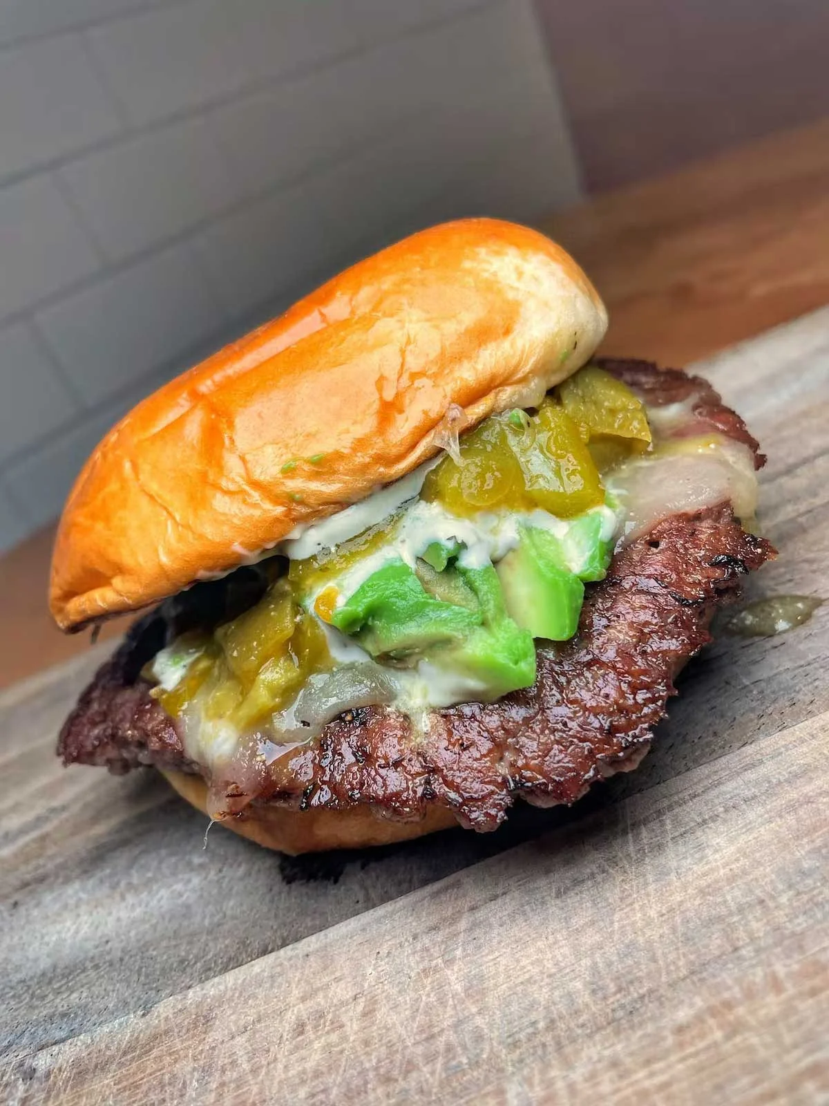 Juicy cheeseburger with green chilies and avocado