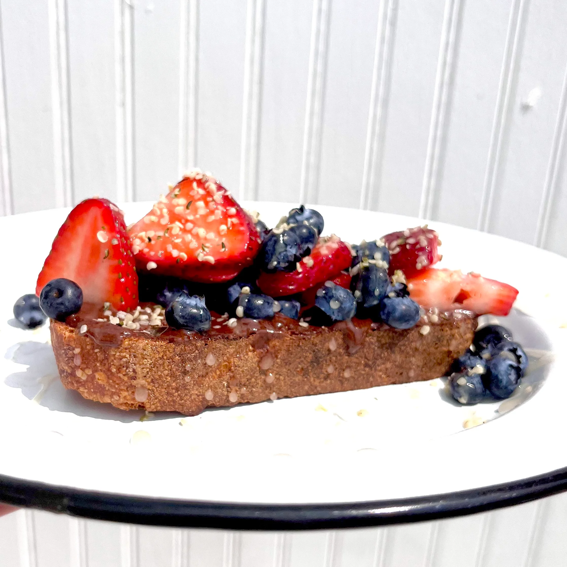 Sliced whole grain toast topped with fresh berries
