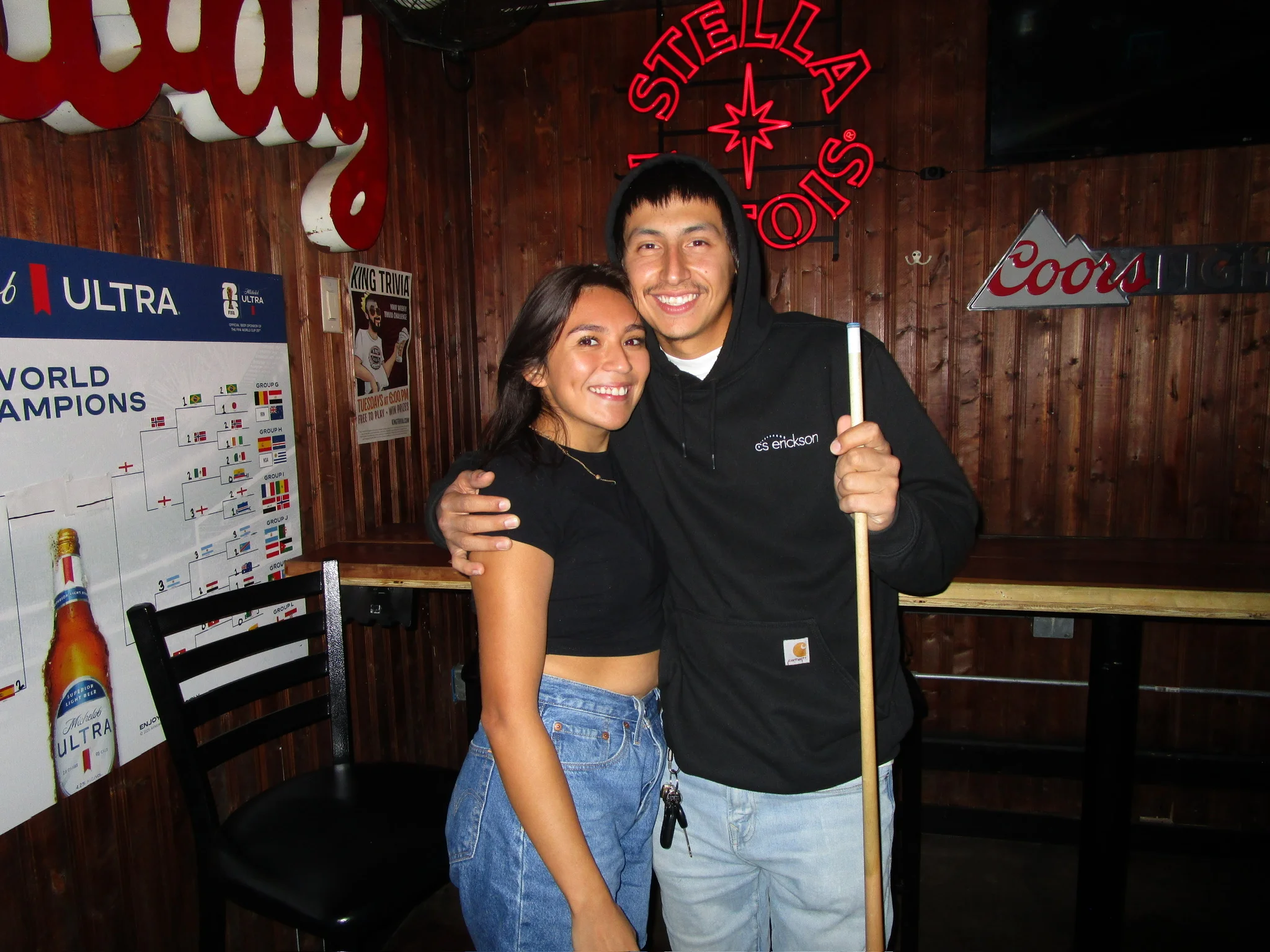 Lively bar scene with patrons enjoying drinks and playing pool