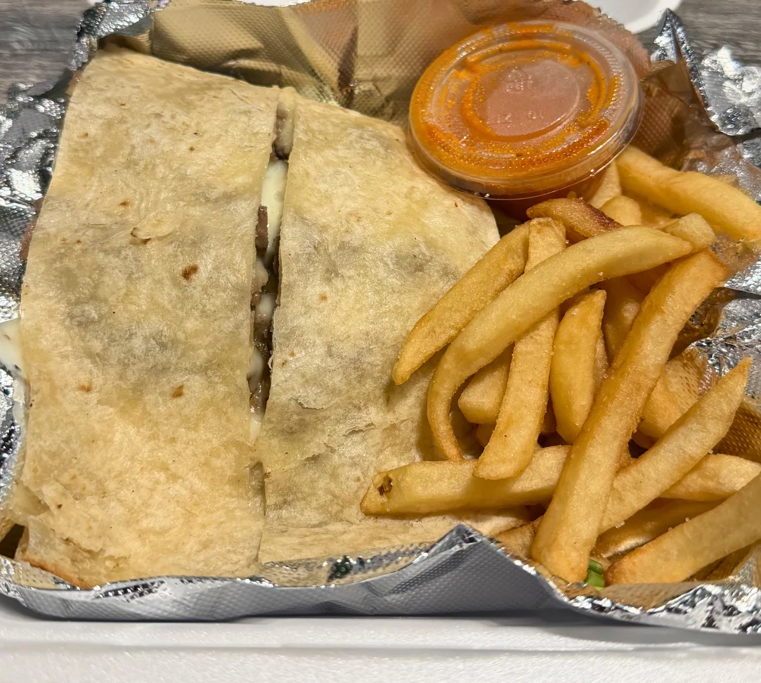 Two sliders with coleslaw and fries in a foil container.