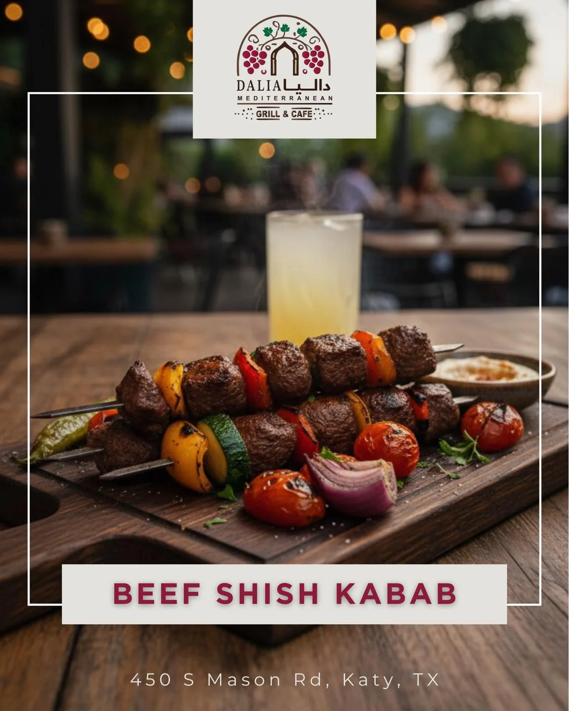 A wooden platter displaying beef shish kabab skewers, accompanied by colorful grilled vegetables and a glass of drink in the background.