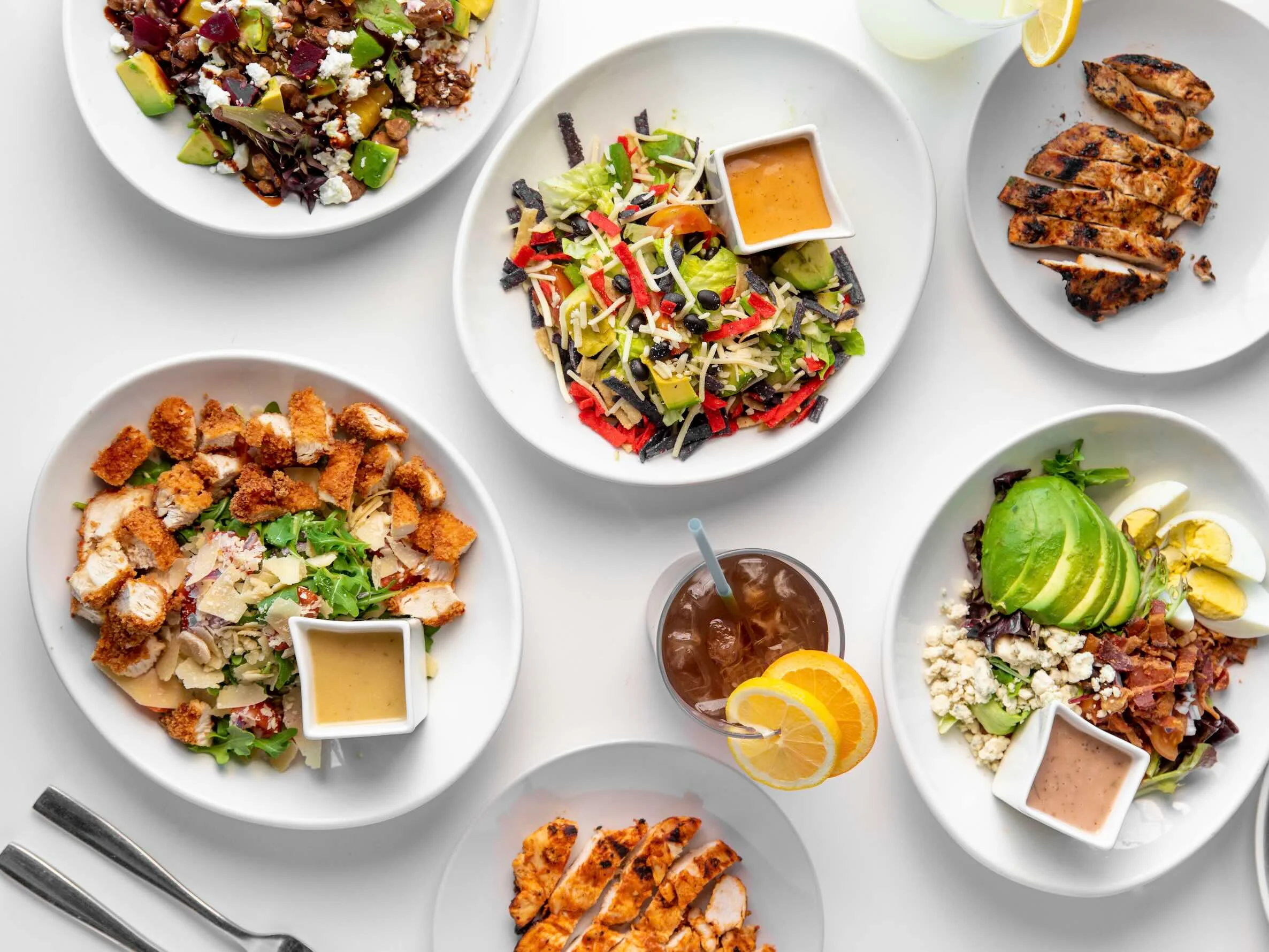 Assorted fresh salads and grilled chicken in a vibrant presentation