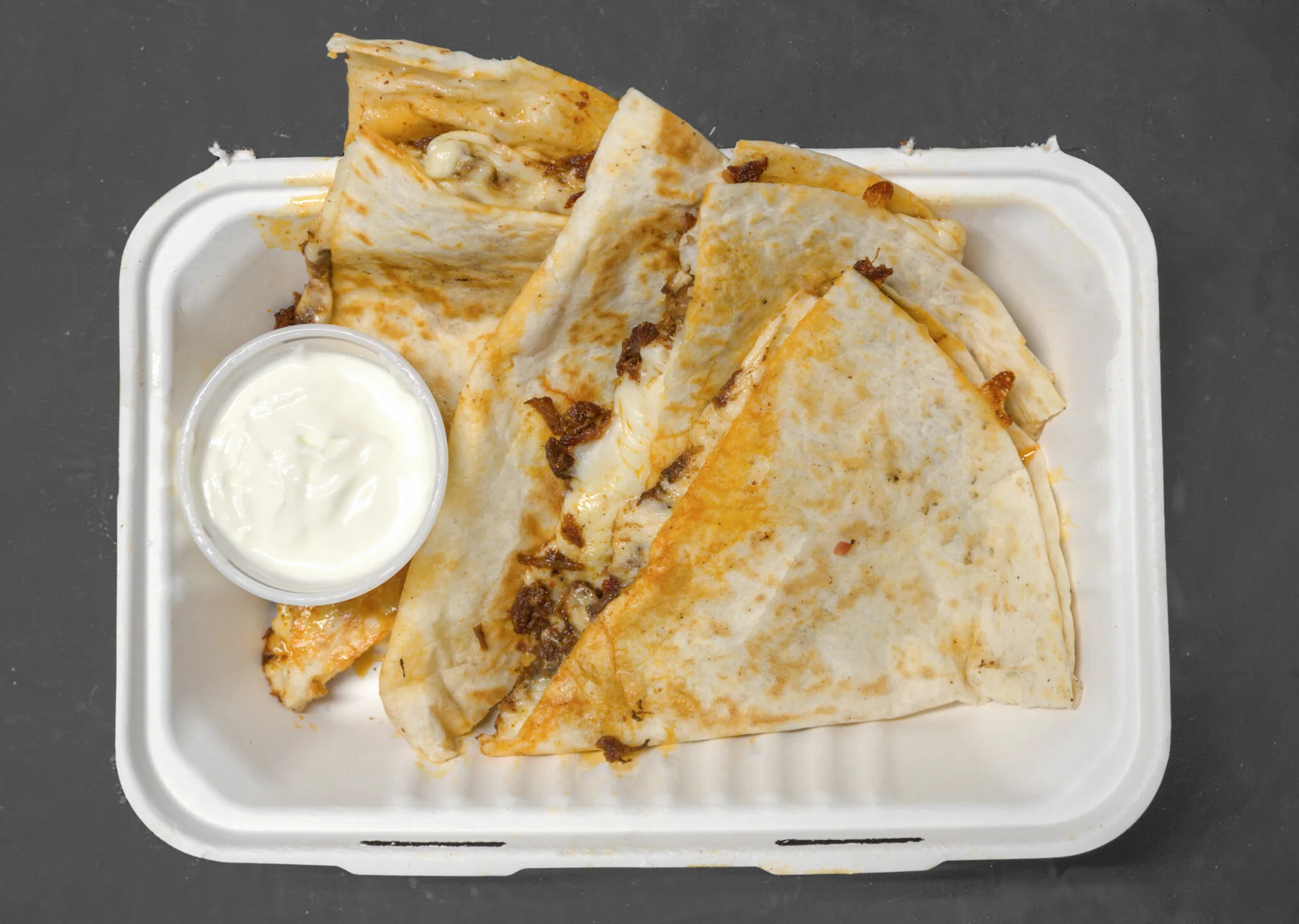 Cheesy quesadilla served with sour cream