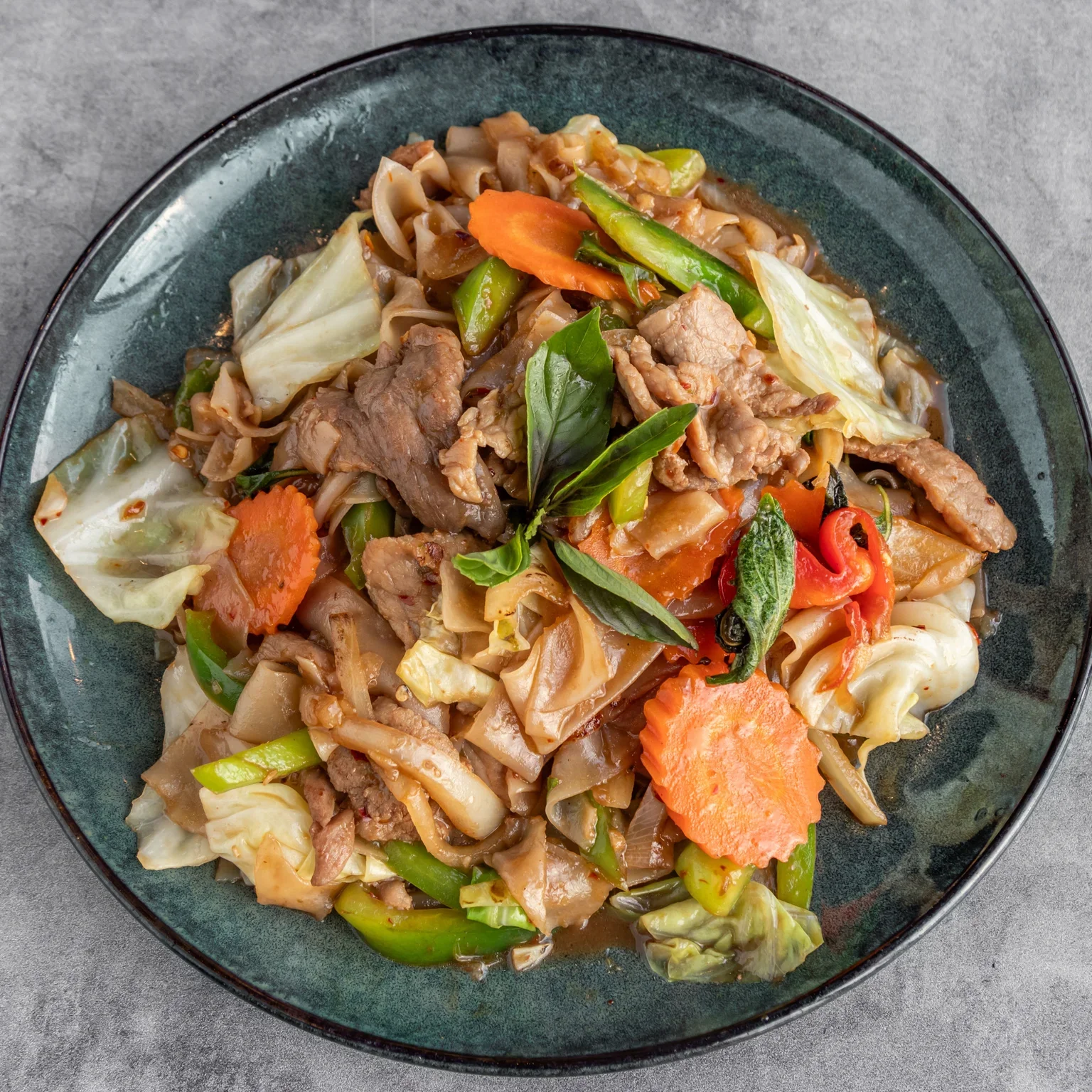 Plate of Pad Kee Mao, a spicy Thai stir-fried noodle dish.