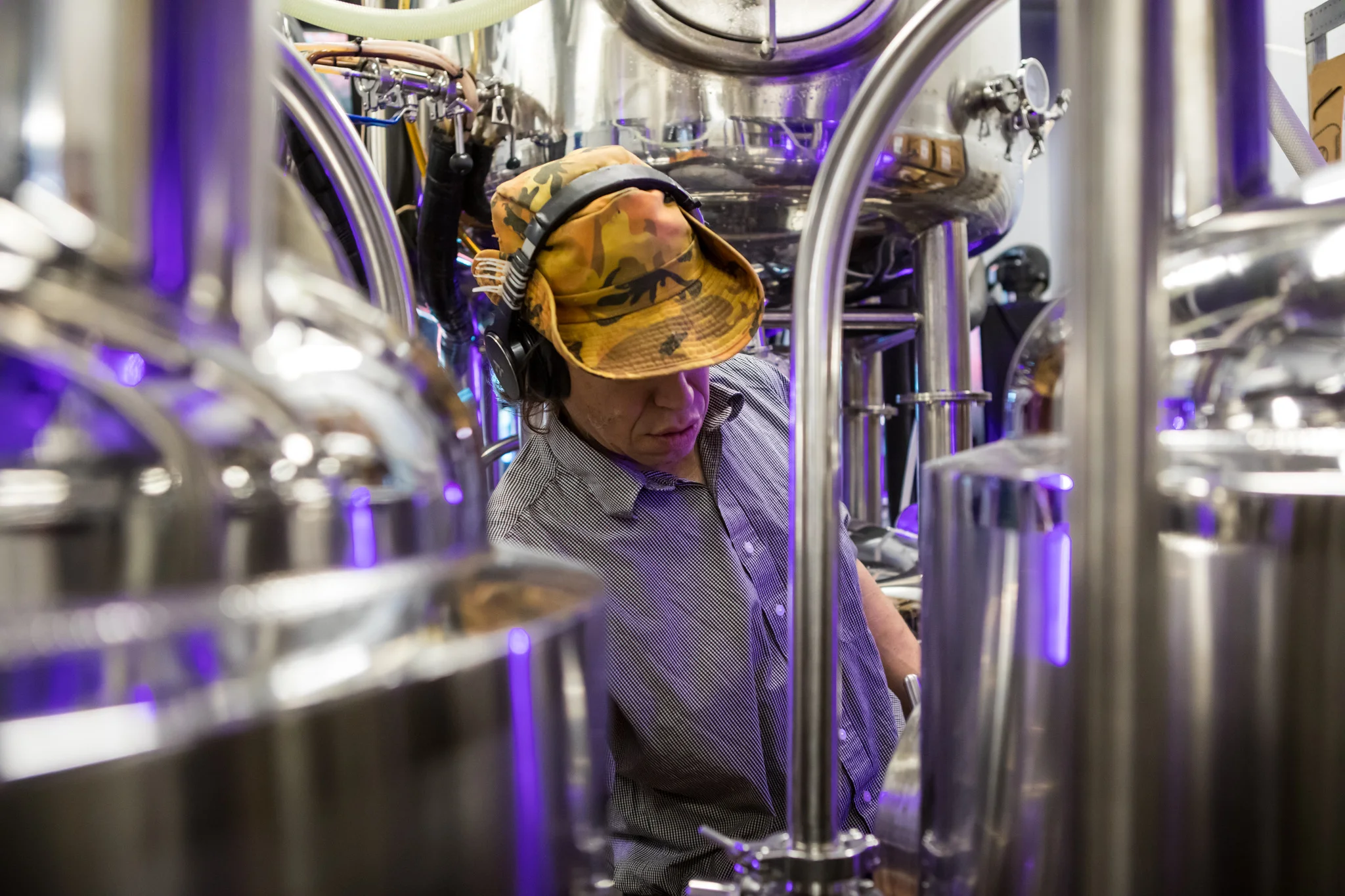 Brewery worker operating equipment in a craft beer facility
