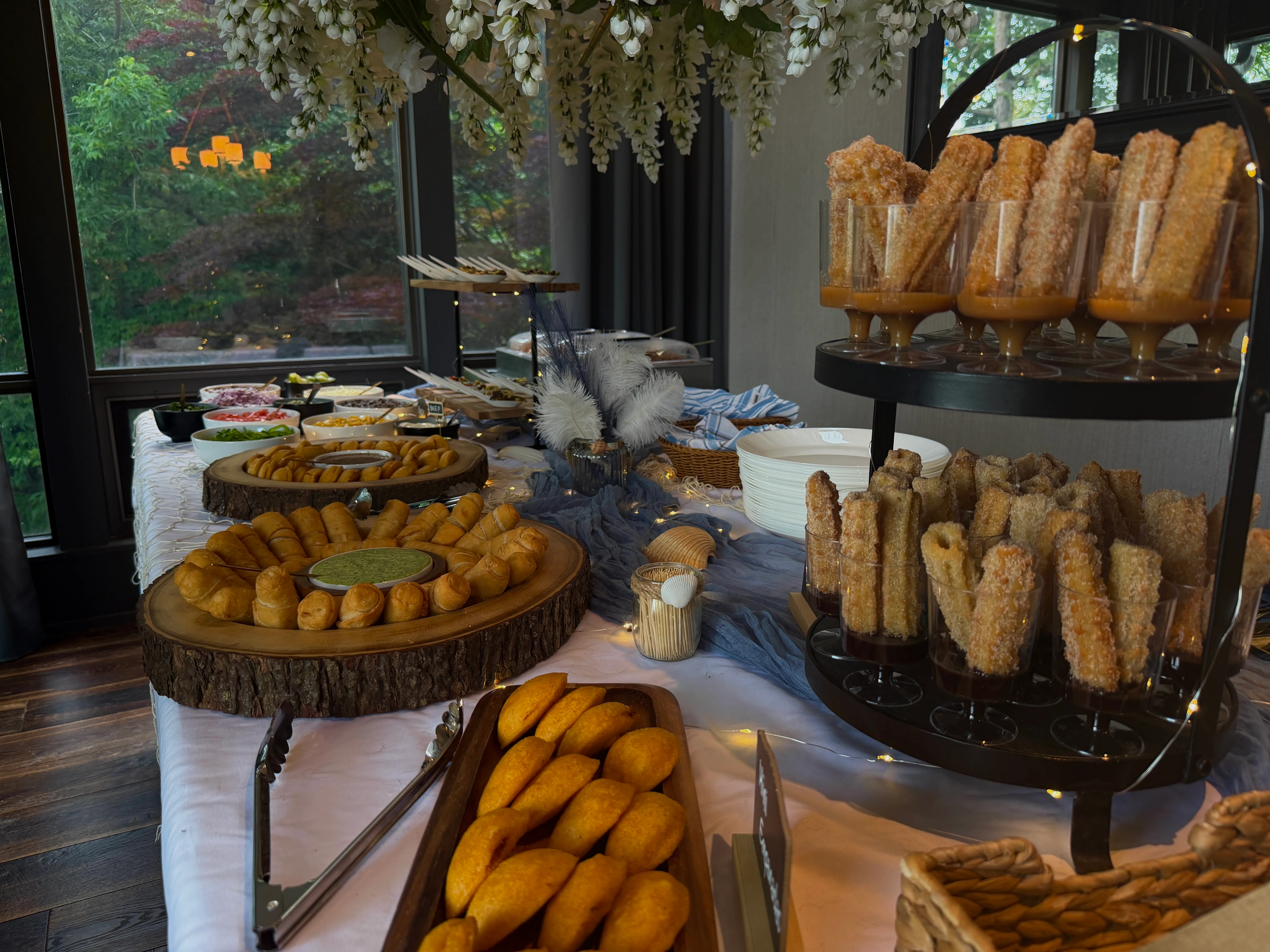 Elegant dessert display featuring churros with chocolate sauce and assorted pastries
