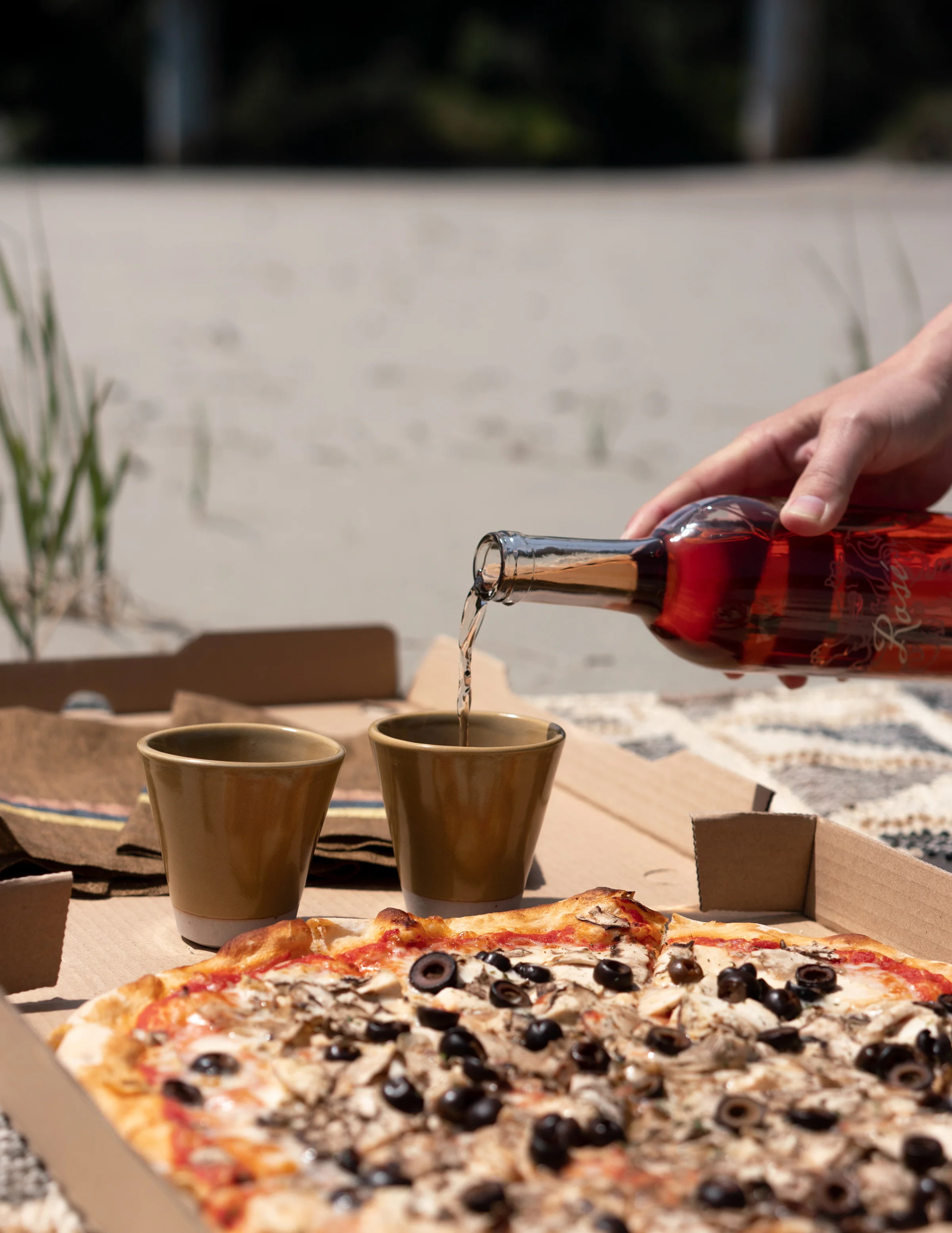 Bottle of wine and pizza at the beach from Frankie's Pizza & Ice Cream in Mendocino, California