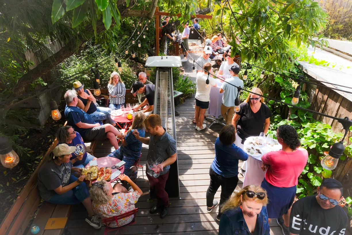Outdoor dining scene with guests enjoying food and drinks
