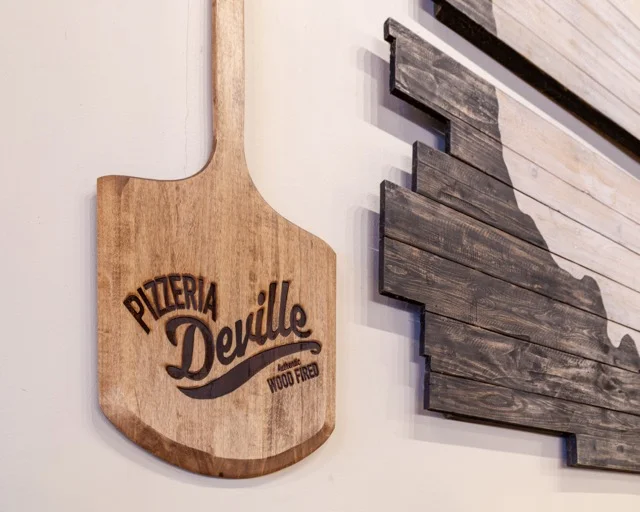 Wood-fired pizza paddle with Pizzeria Deville branding