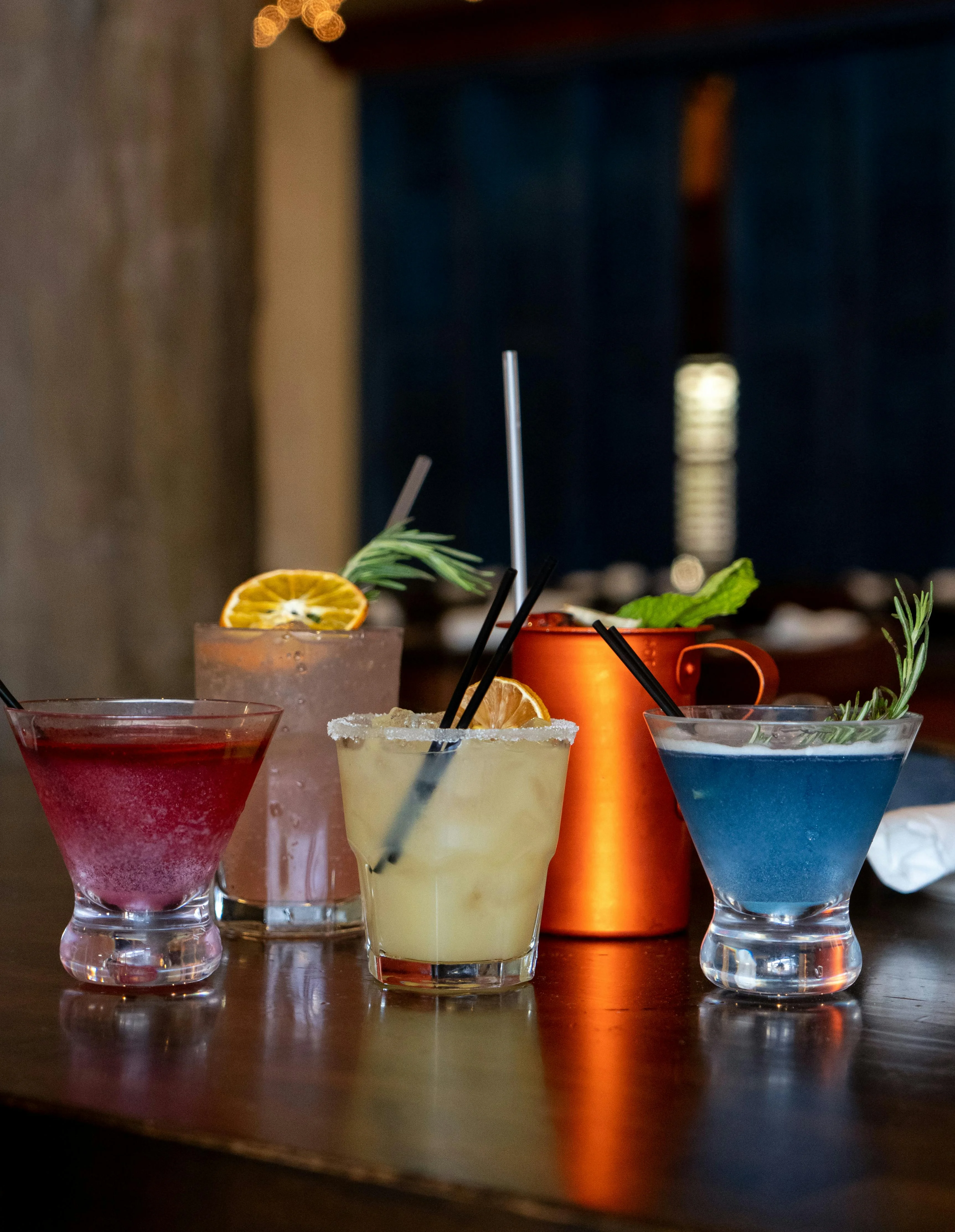 Colorful cocktails on a wooden bar counter