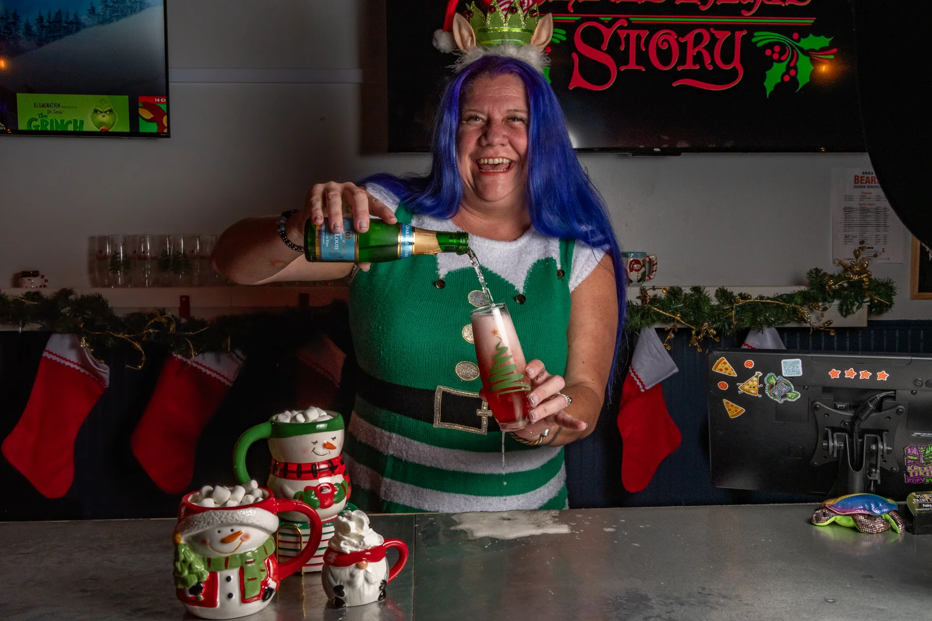 Bartender pouring festive cocktail at holiday-themed bar