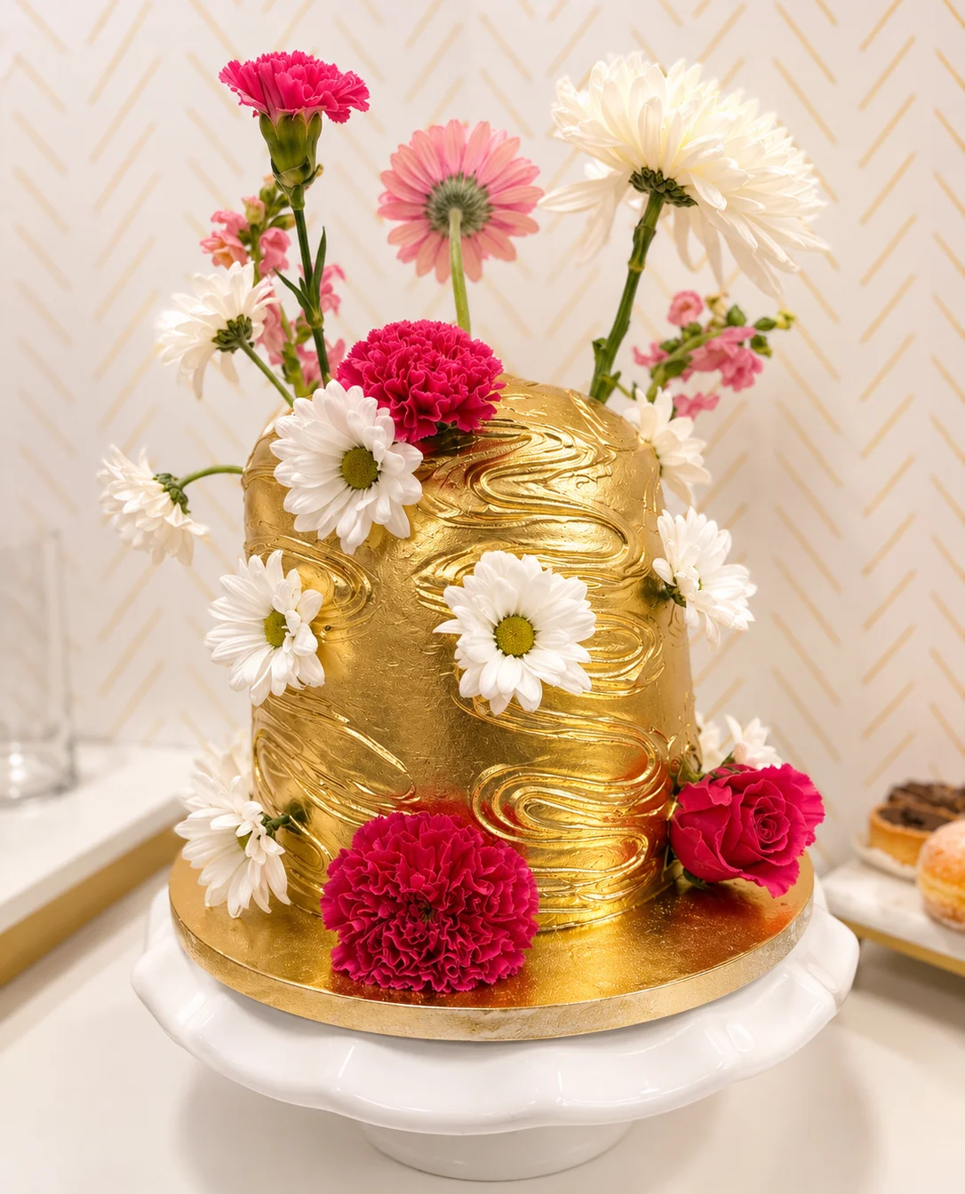 Elegant gold cake adorned with fresh flowers