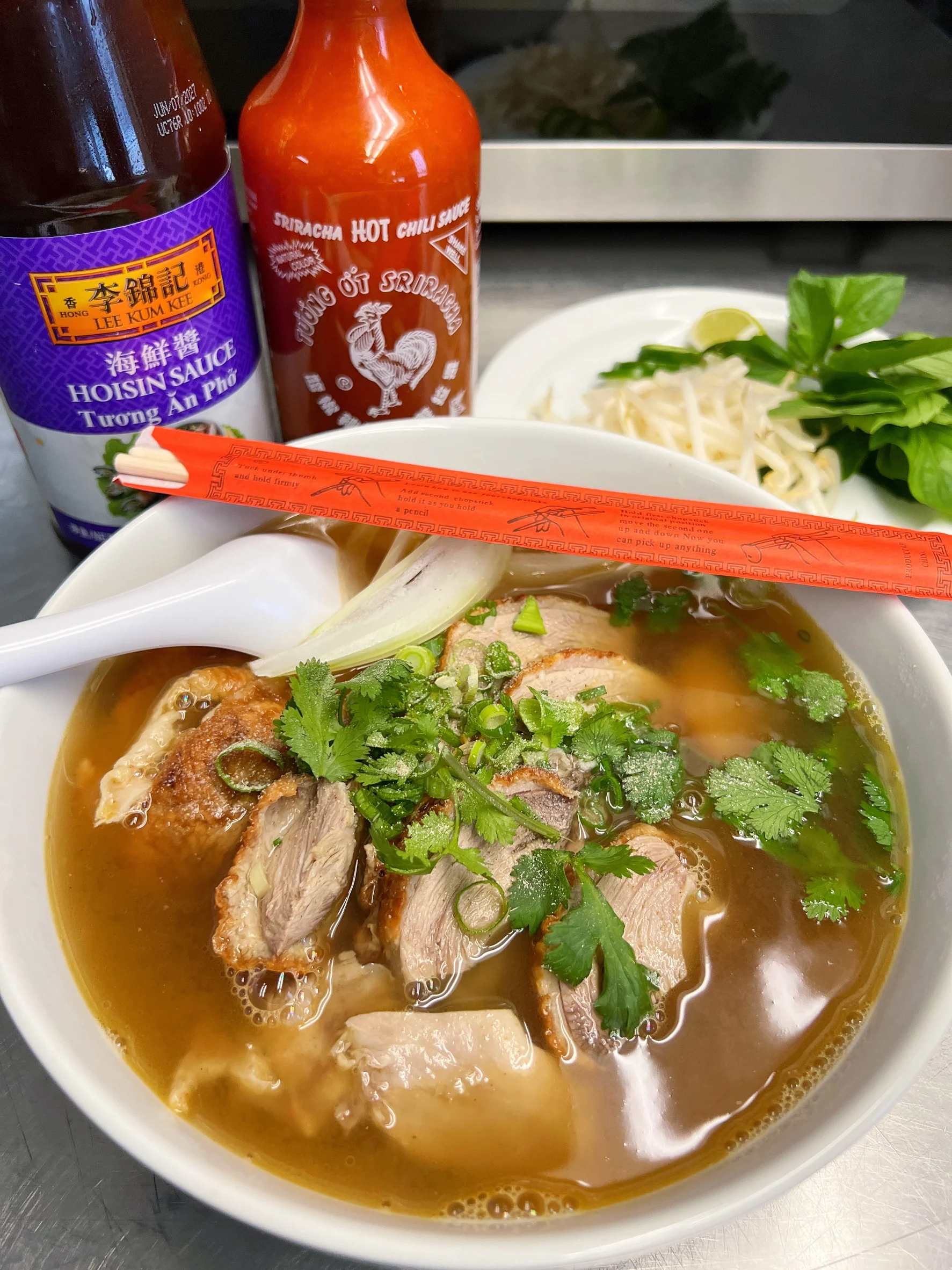Bowl of Vietnamese pho with sliced meat and fresh herbs