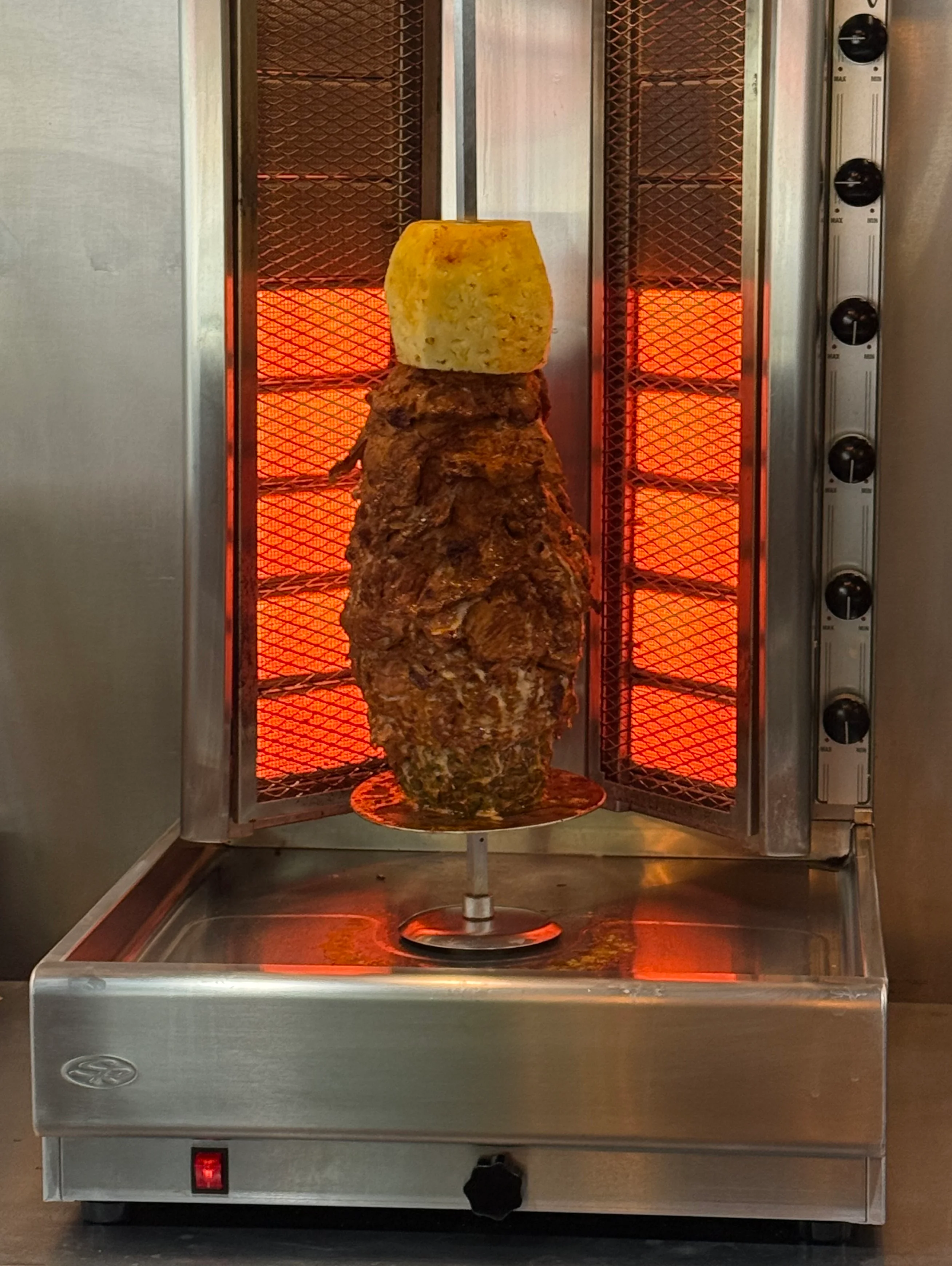 Vertical spit of al pastor with pineapple in a restaurant kitchen