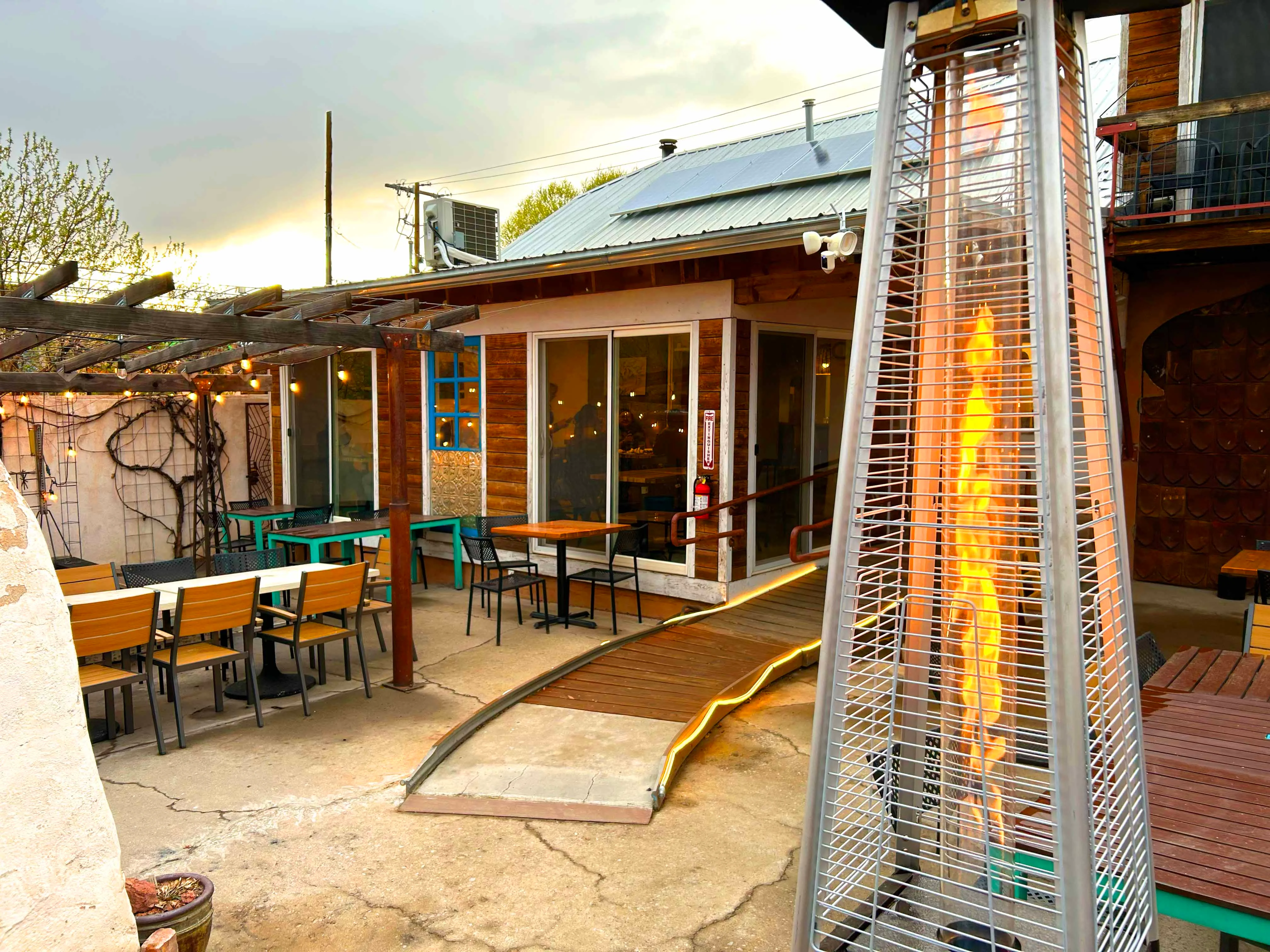 Cozy outdoor dining area with patio heaters and string lights