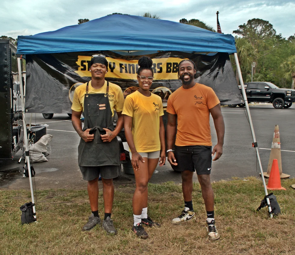 Team members at a BBQ food stall promoting their business