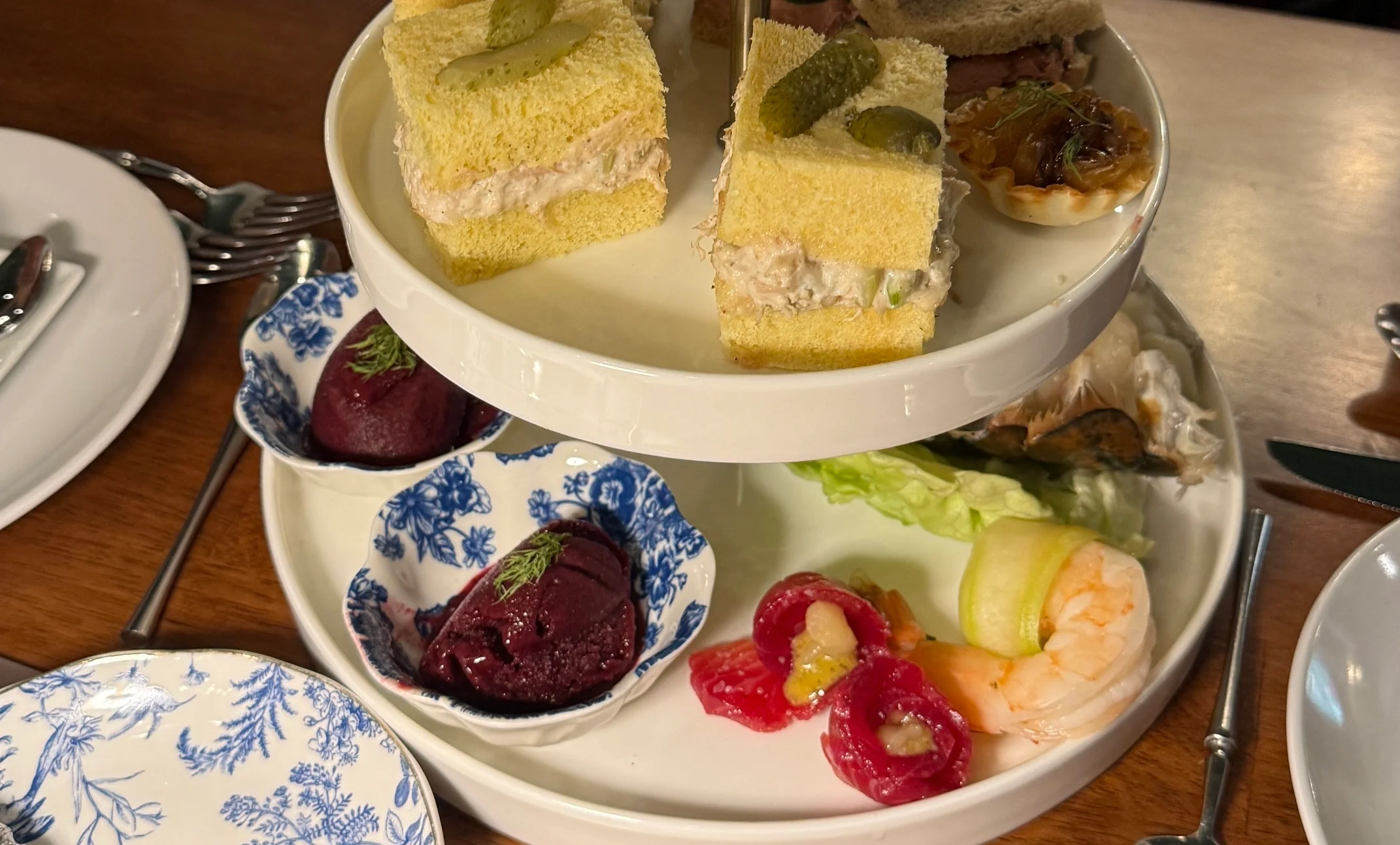Elegant afternoon tea tiered stand with assorted pastries and sandwiches