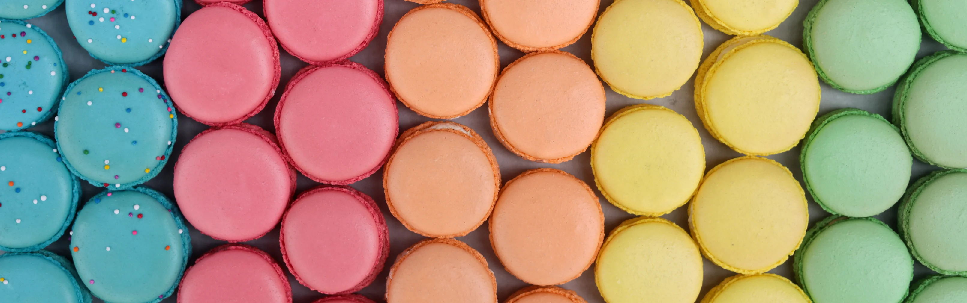 Colorful assortment of French macarons arranged in a vibrant pattern